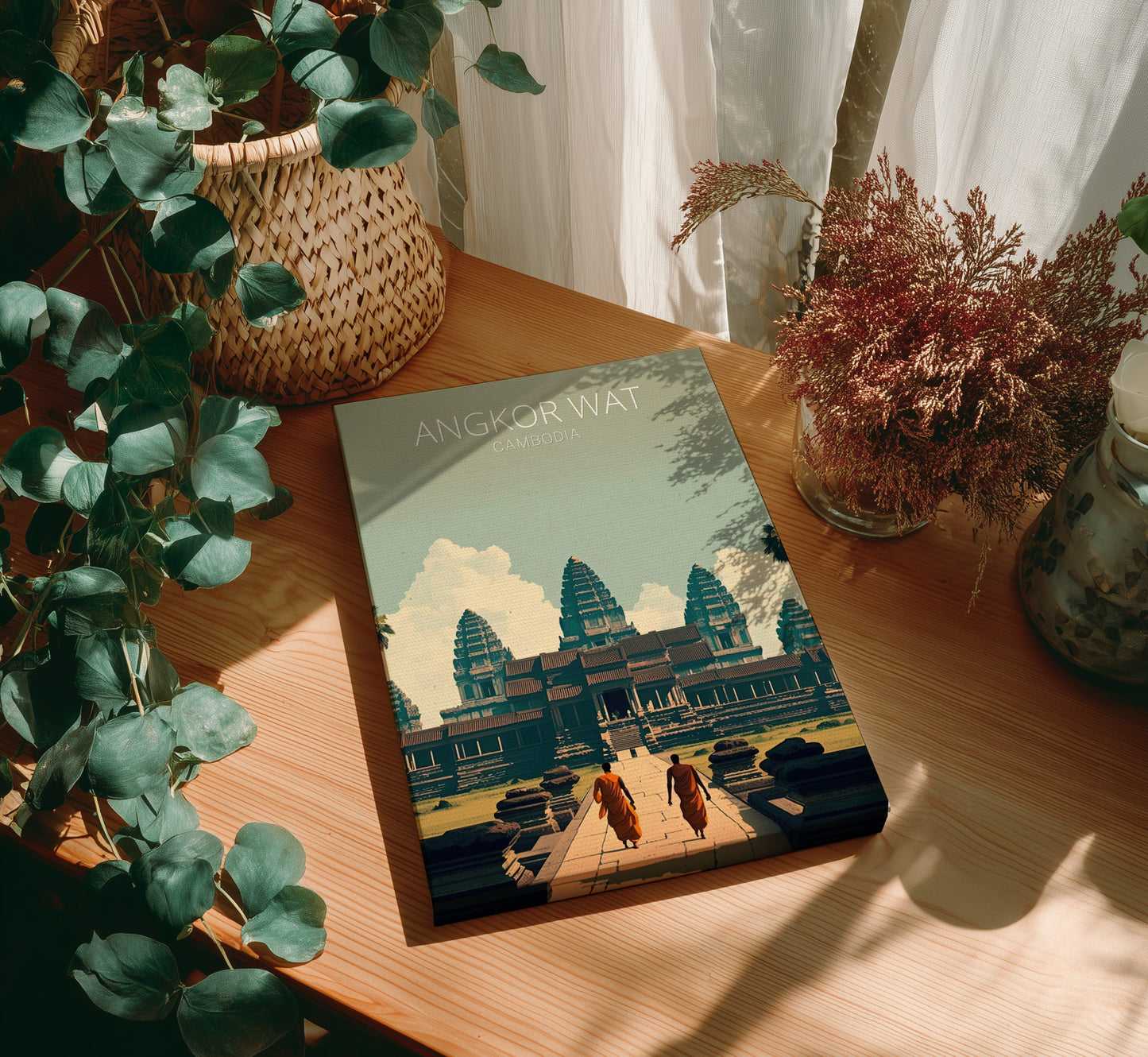Book titled 'Angkor Wat' on a wooden table with plants