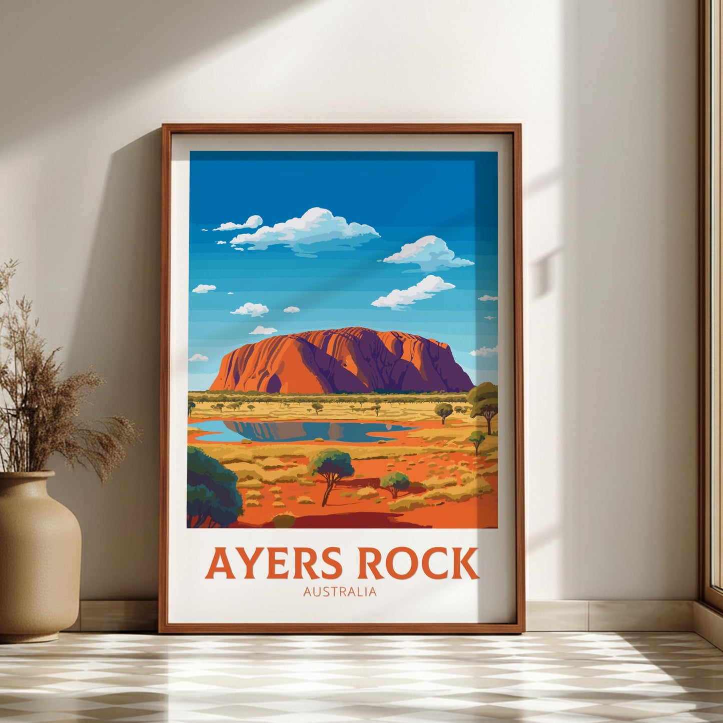 Framed poster of Ayers Rock with a wooden frame on a wall.
