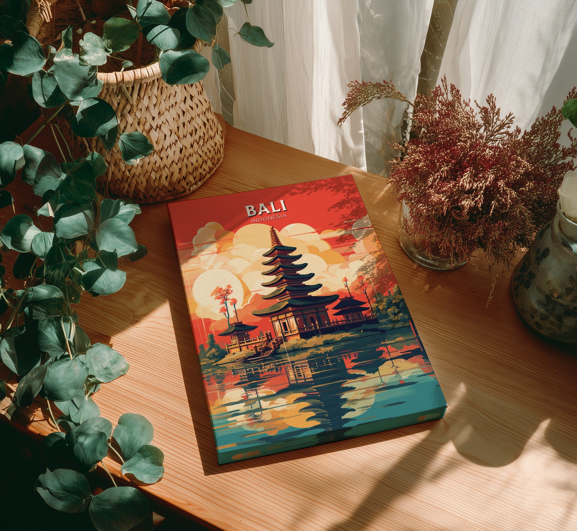 Colorful book titled 'Bali' on a wooden table with plants around