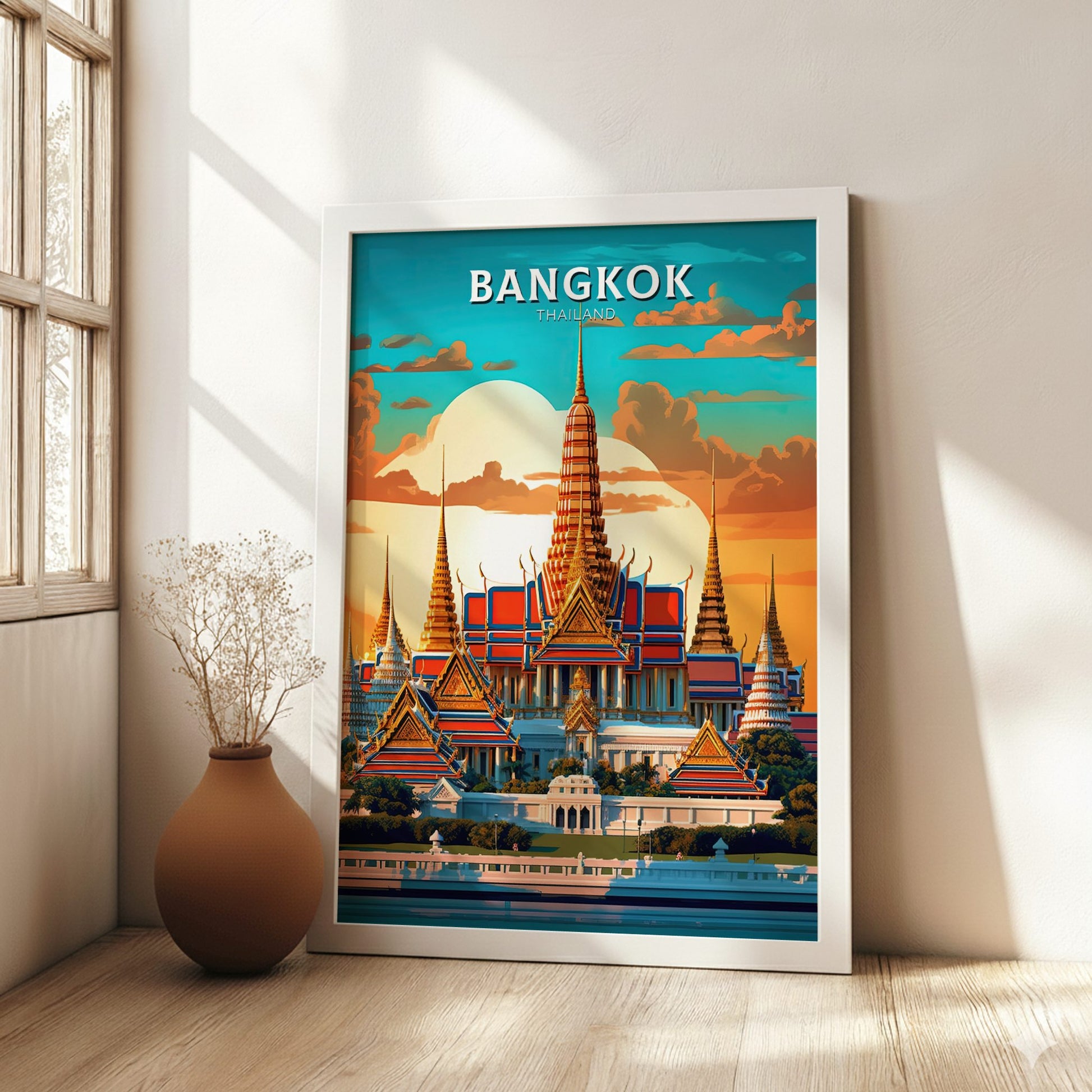 Framed poster of Bangkok with a temple design in a room with a vase and plant.