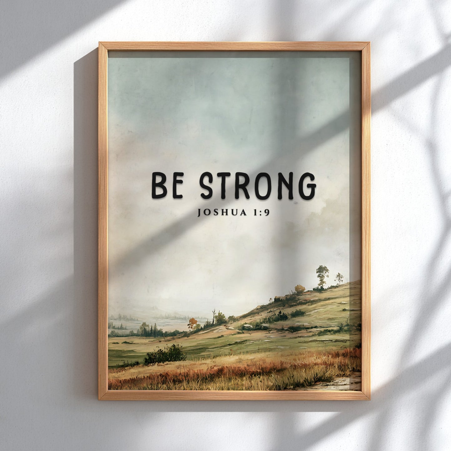 Be Strong poster featuring a serene landscape and inspirational message from Joshua 1:9 in soft greens and