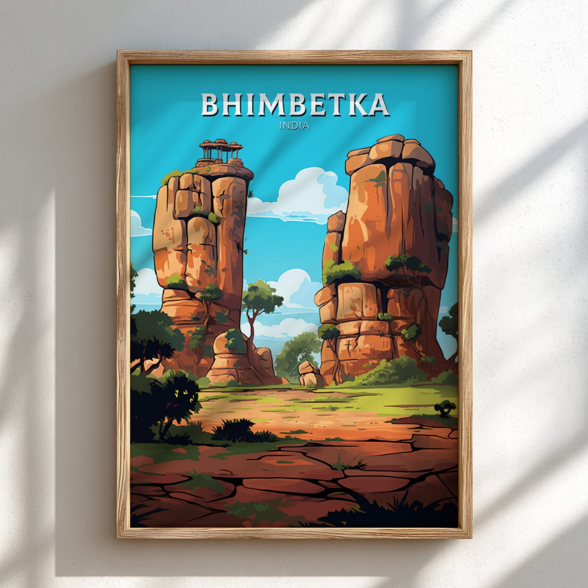 Framed poster of Bhimbetka with rock formations and trees on a white wall.