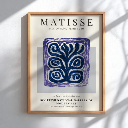 Framed Matisse art print with blue swirling plant form on a white wall.