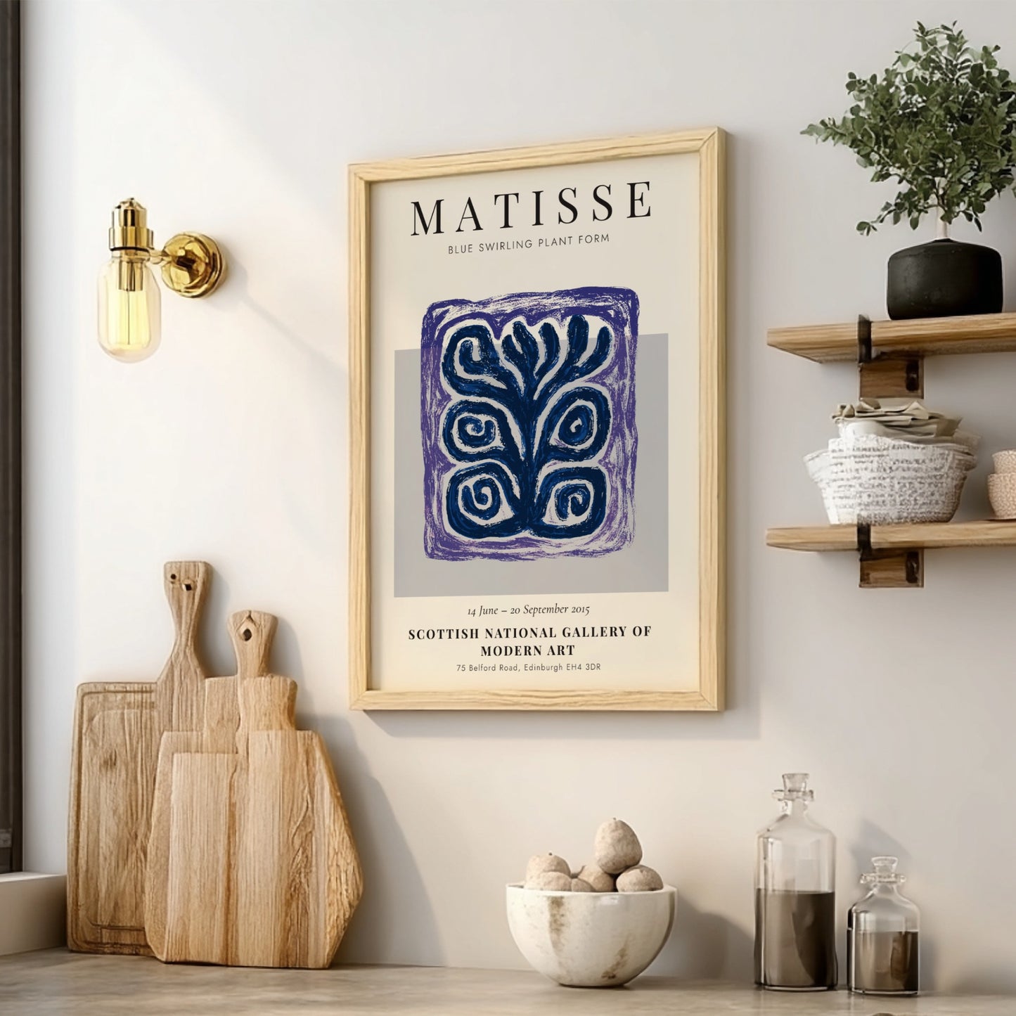 Framed Matisse artwork on a wall with wooden cutting boards and decor items below.