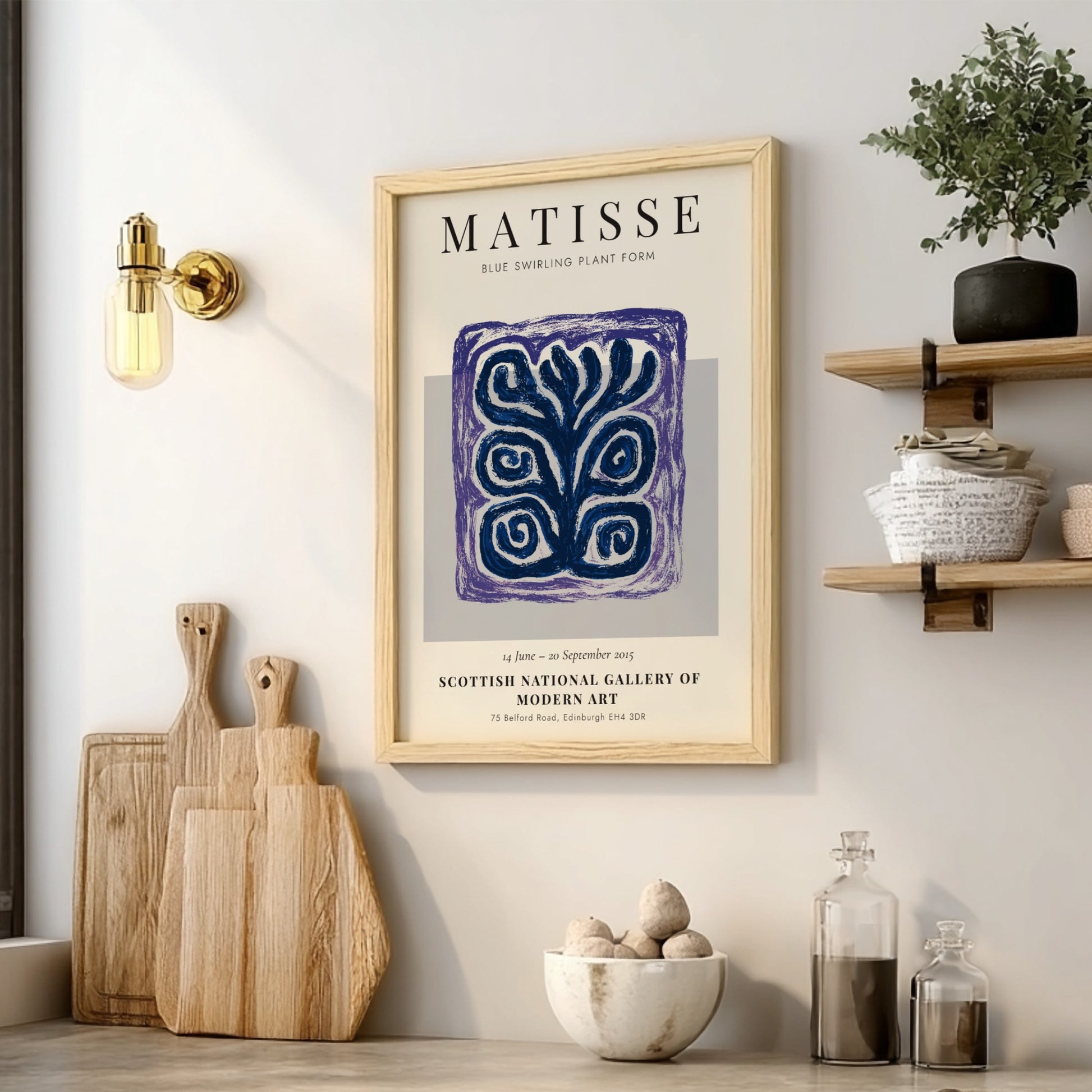 Framed Matisse artwork on a wall with wooden cutting boards and decor items below.