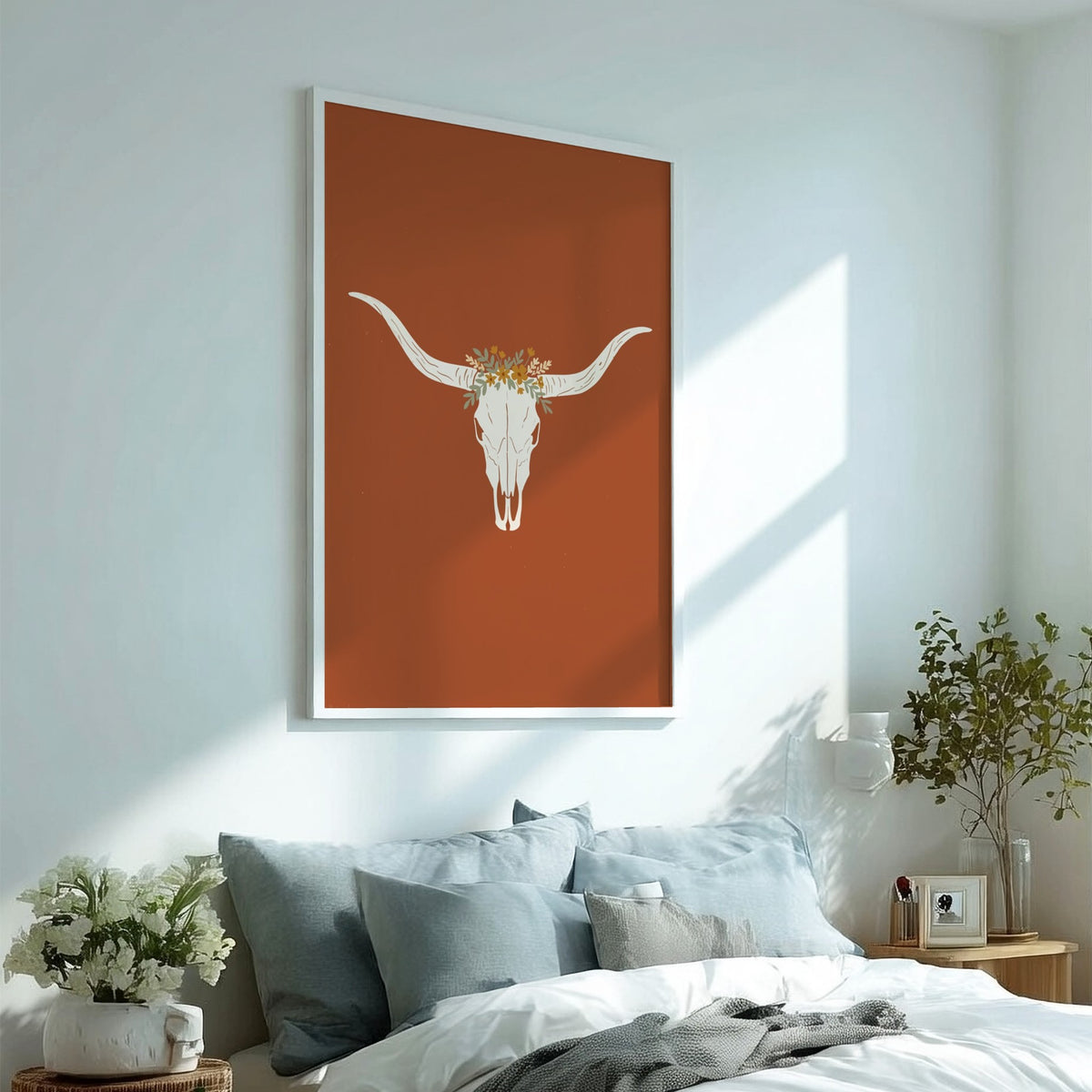 Poster featuring a white bull skull with a wildflower crown on terracotta background