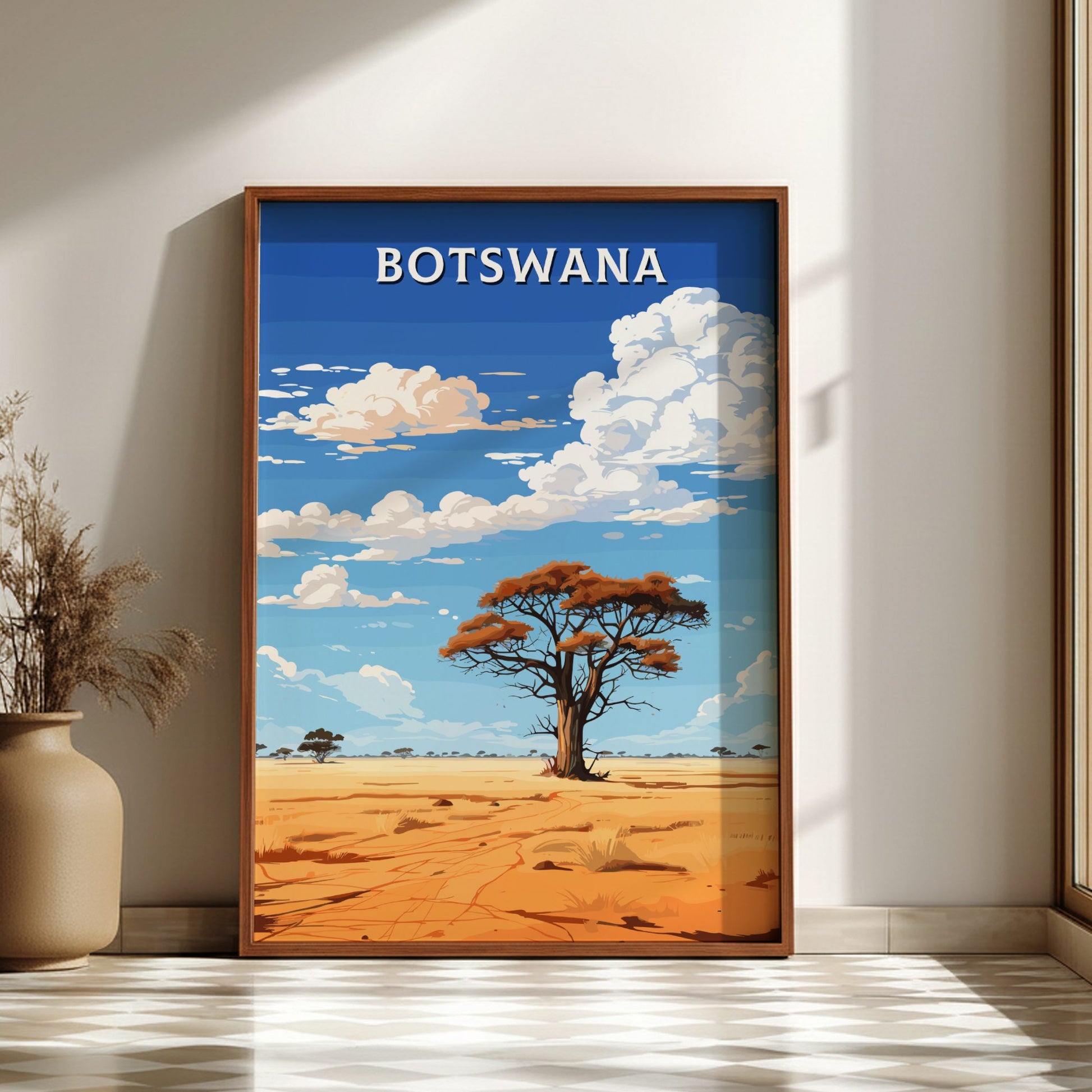 Framed artwork of a desert landscape with a tree and 'BOTSWANA' text on a wall.