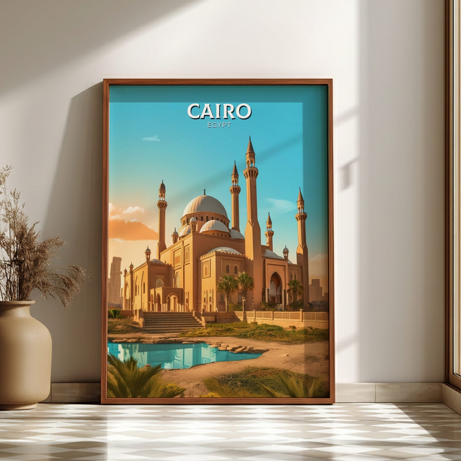 Framed poster of a mosque in Cairo on a wall with a vase and plant.