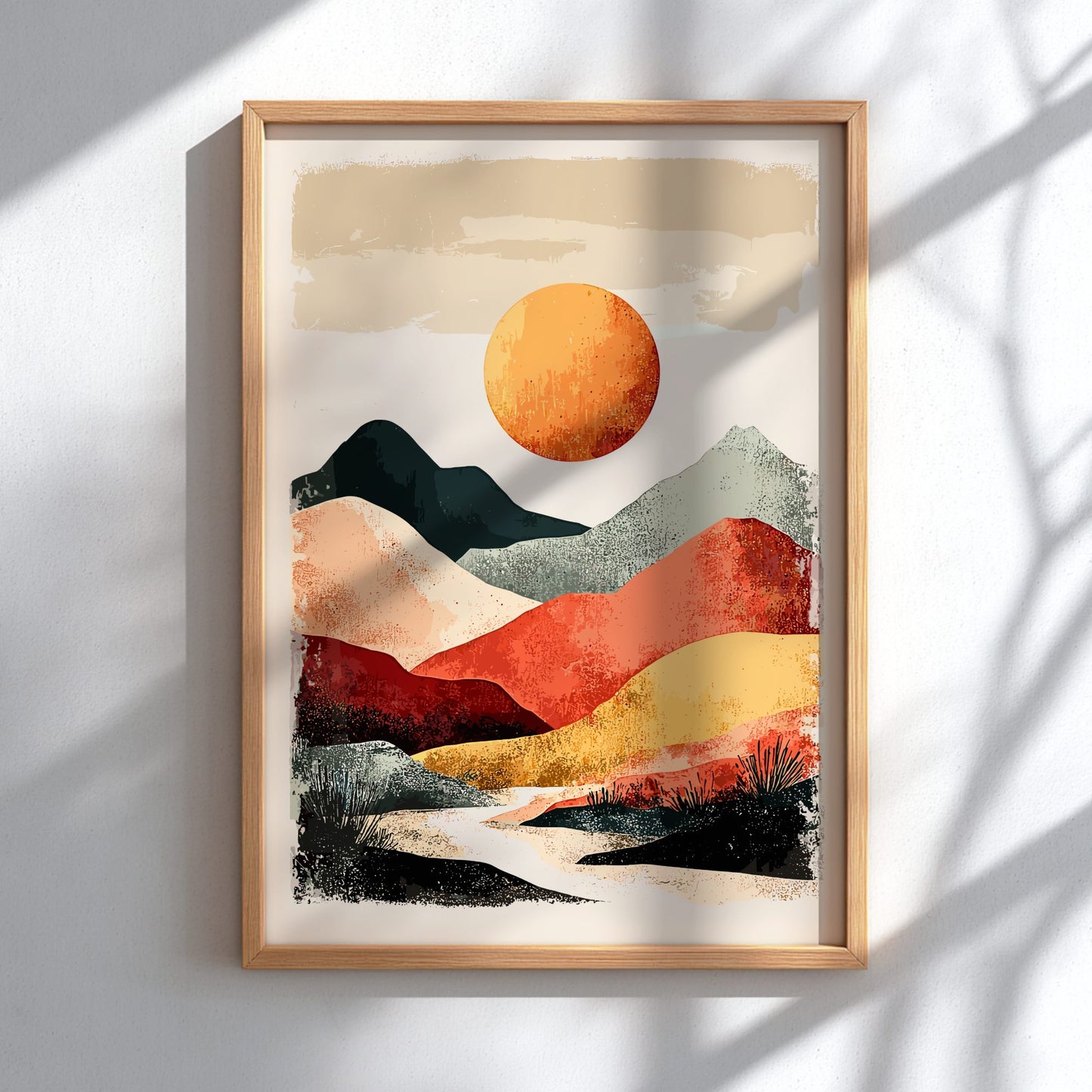 Framed abstract landscape art with a sun and mountains on a white wall.