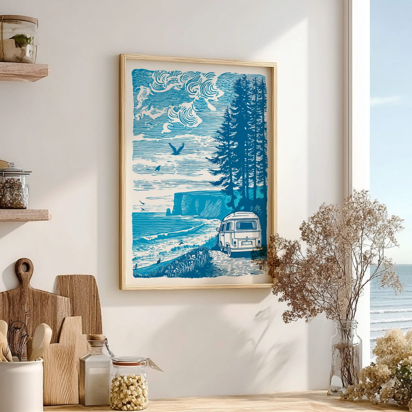 Framed artwork of a coastal scene with a van, trees, and ocean on a wall in a room with decor elements.