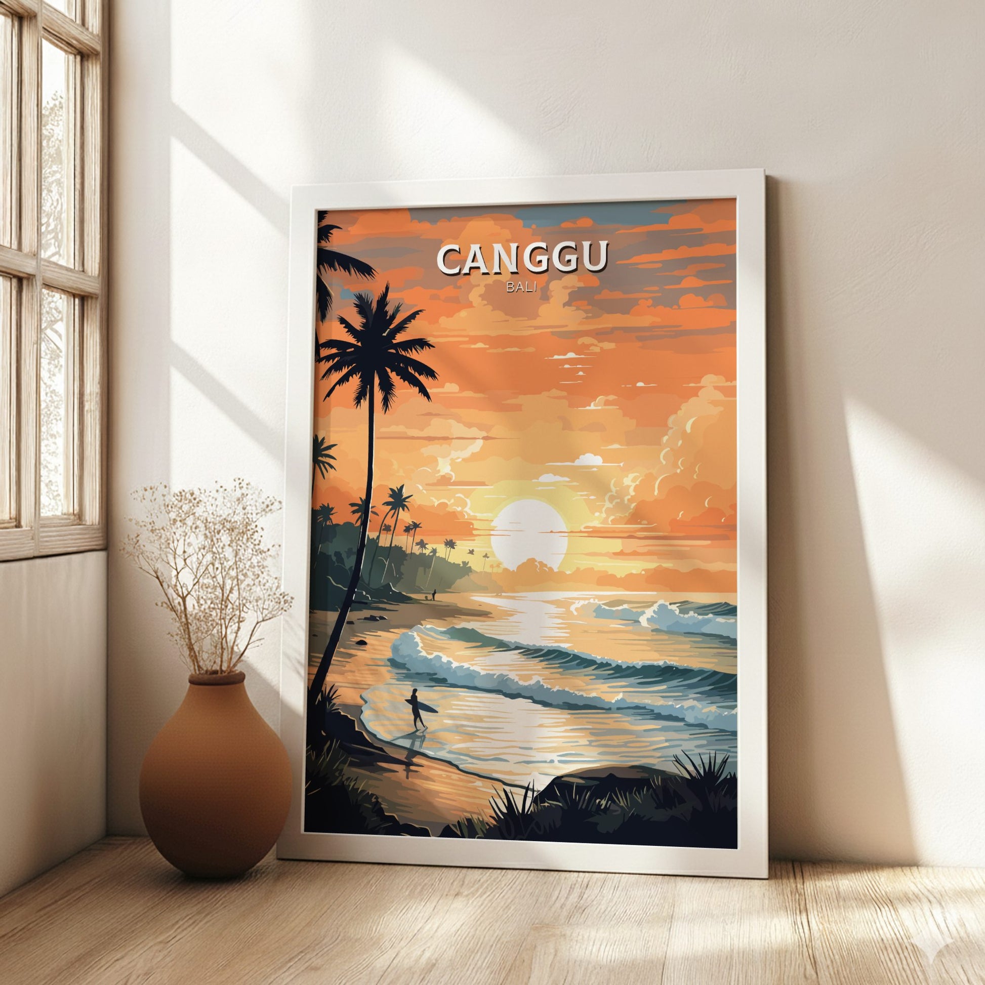 Framed artwork of a tropical sunset scene with 'Canggu' text, placed on a wall next to a window.