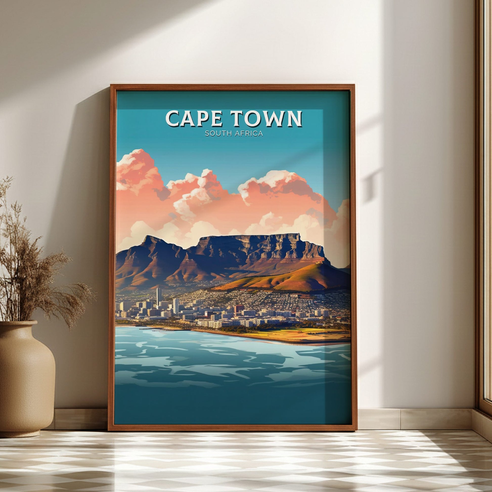 Framed poster of Cape Town with Table Mountain and cityscape, on a wall with a vase and plant.