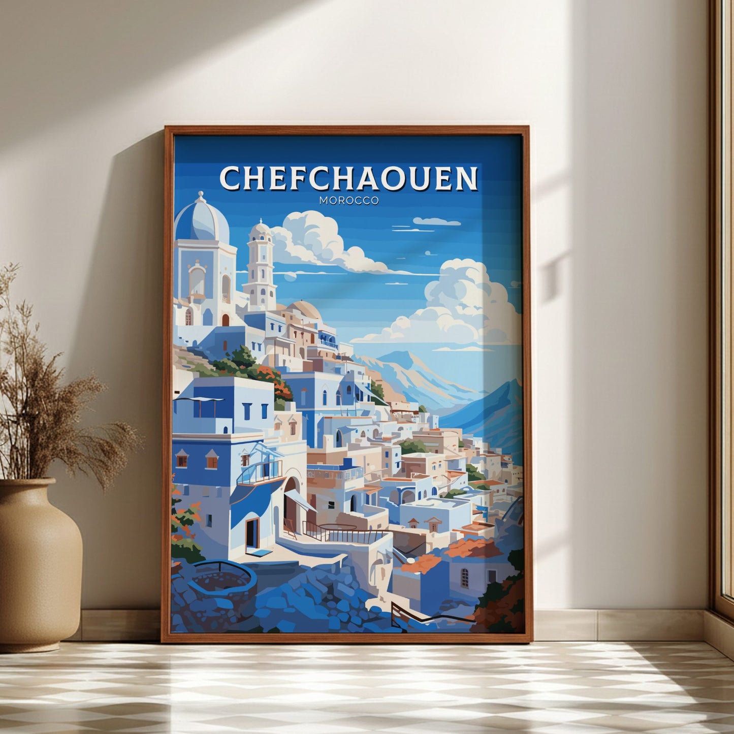 Framed poster of Chefchaouen with a cityscape on a blue sky background, placed on a light wooden floor.