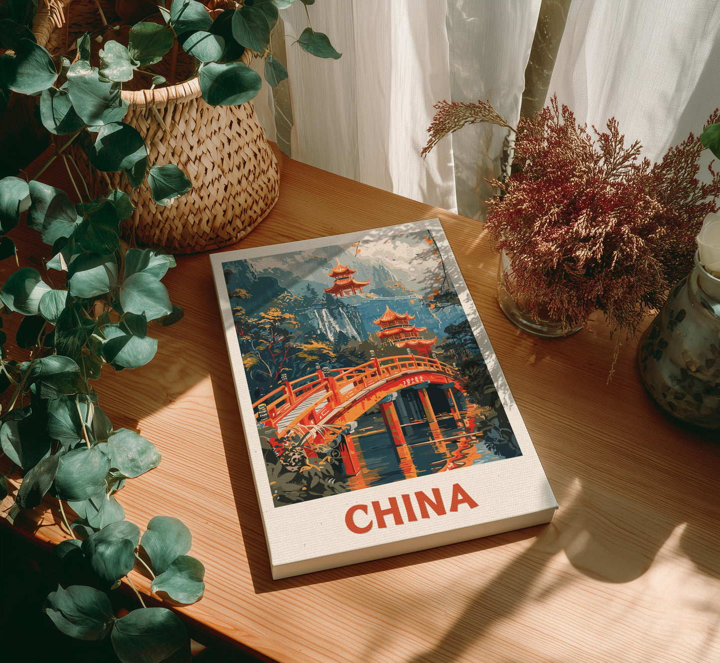 Canvas of 'China' with a scenic cover on a wooden table surrounded by plants