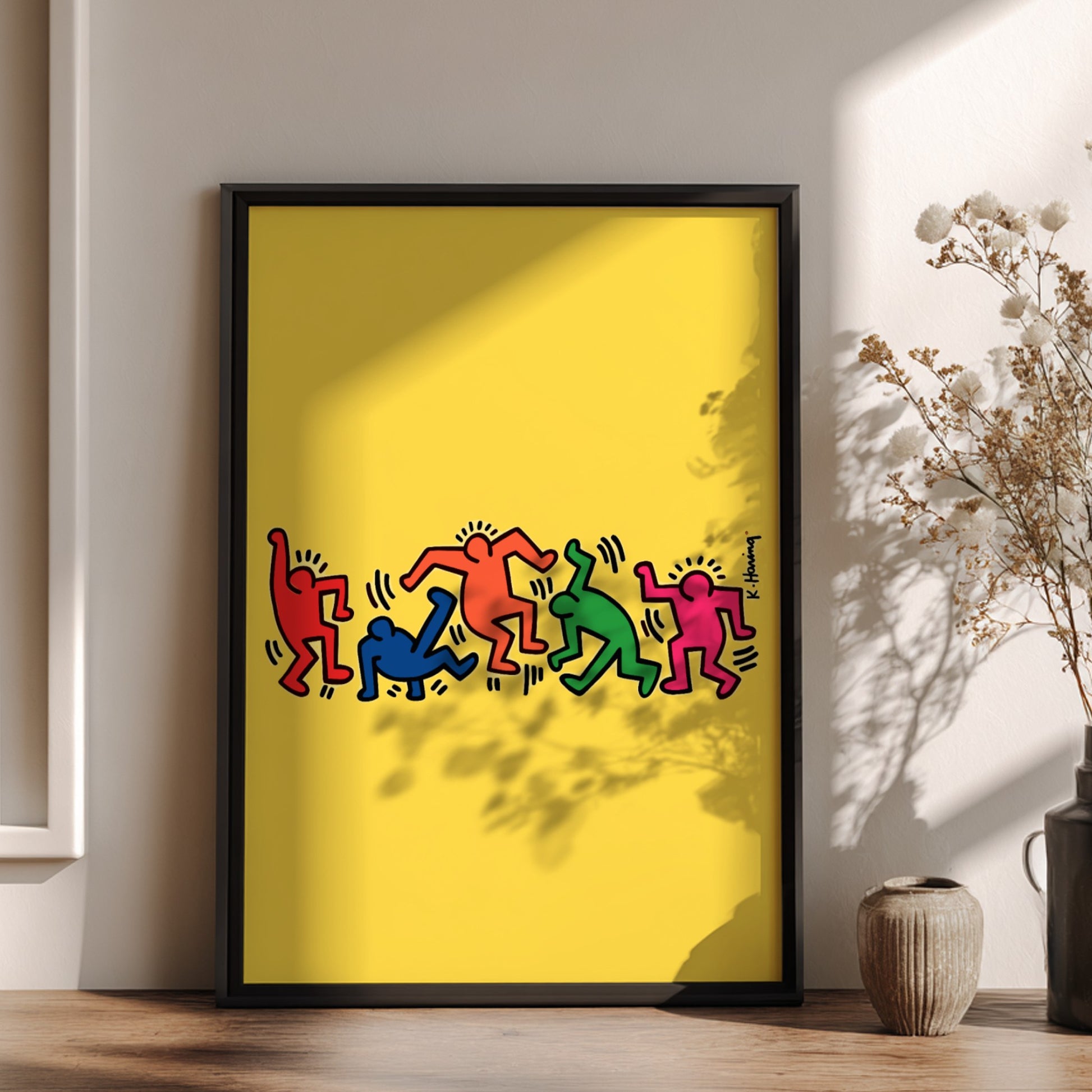 Keith Haring "Dancing Figures" poster with colorful figures on a yellow background.