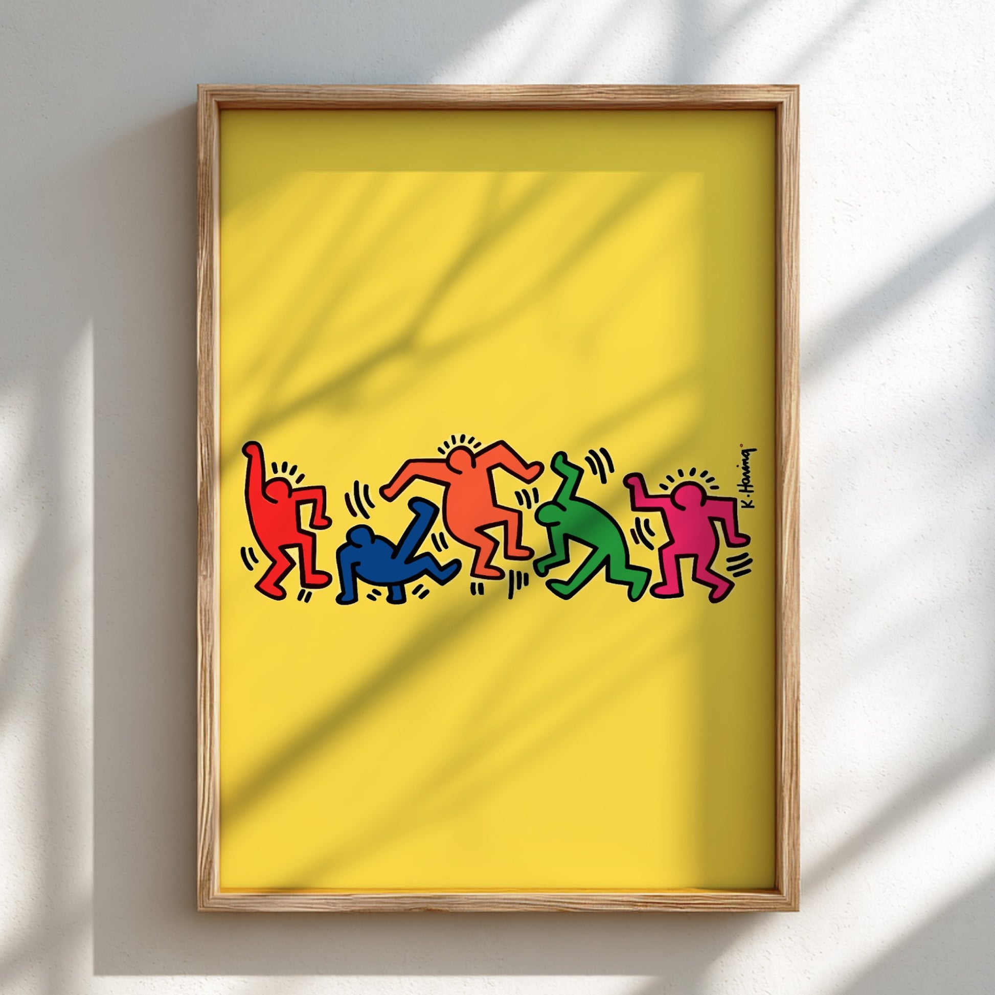 Keith Haring "Dancing Figures" poster with colorful figures on a yellow background.