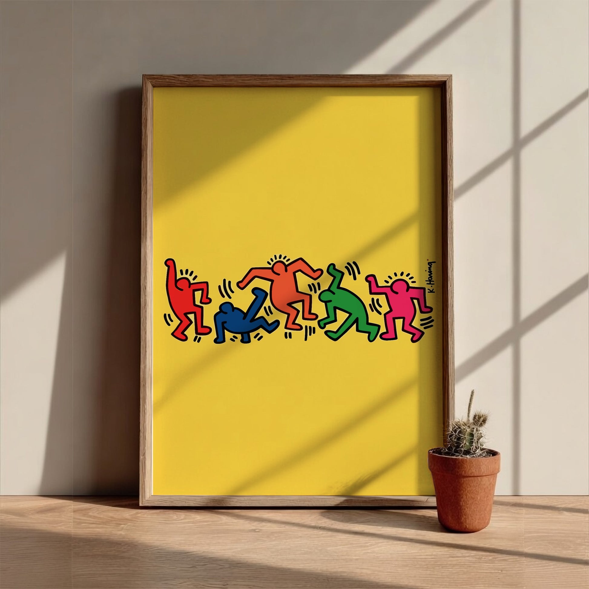 Keith Haring "Dancing Figures" poster with colorful figures on a yellow background.