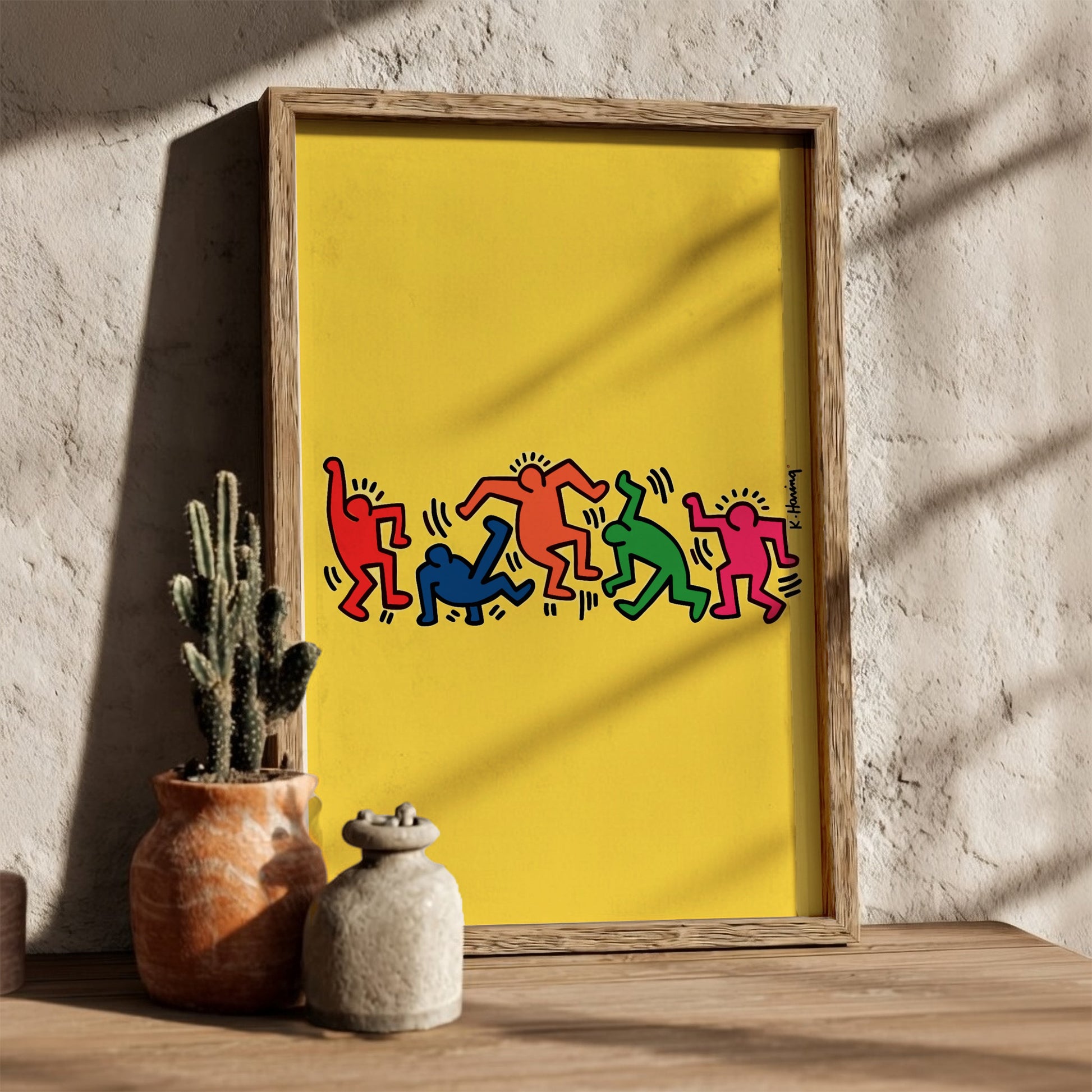 Keith Haring "Dancing Figures" poster with colorful figures on a yellow background.