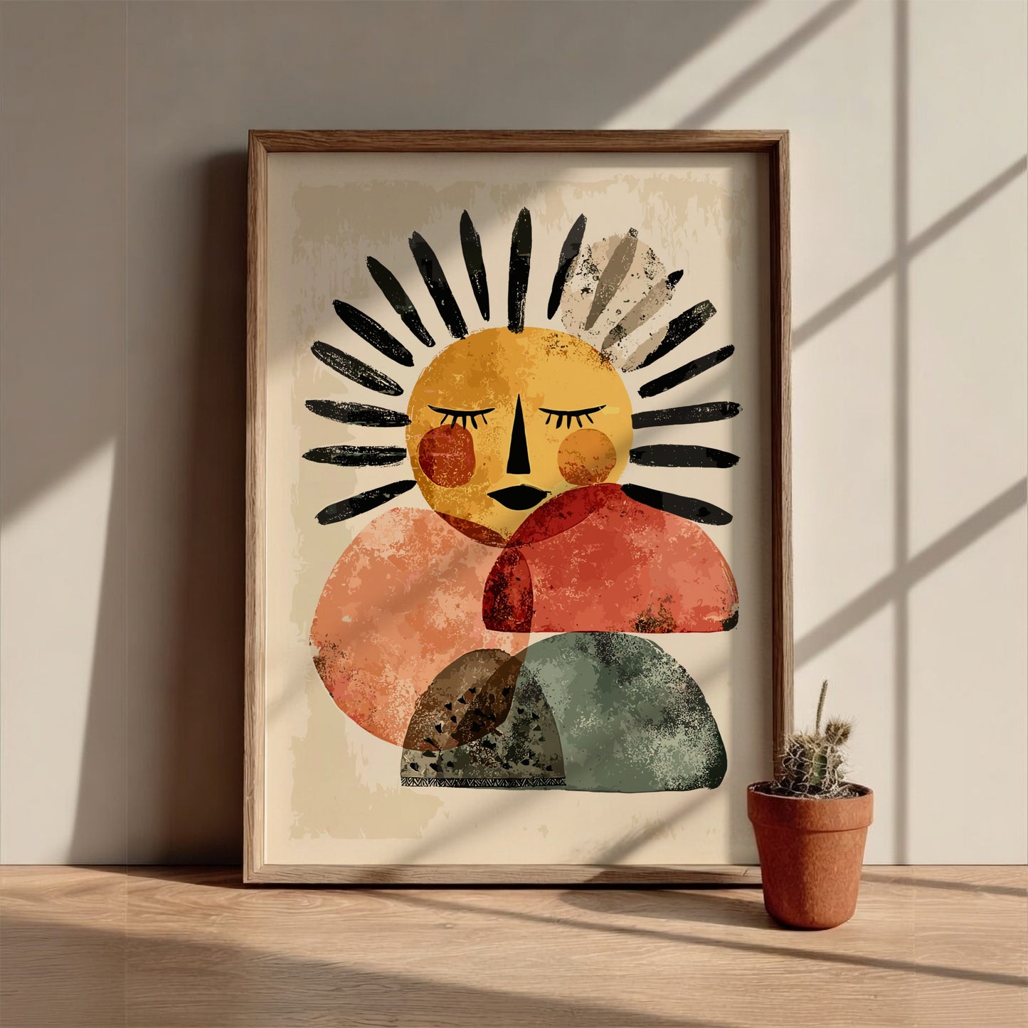 Framed abstract art print of a sun-like figure on a wall with a potted plant below.