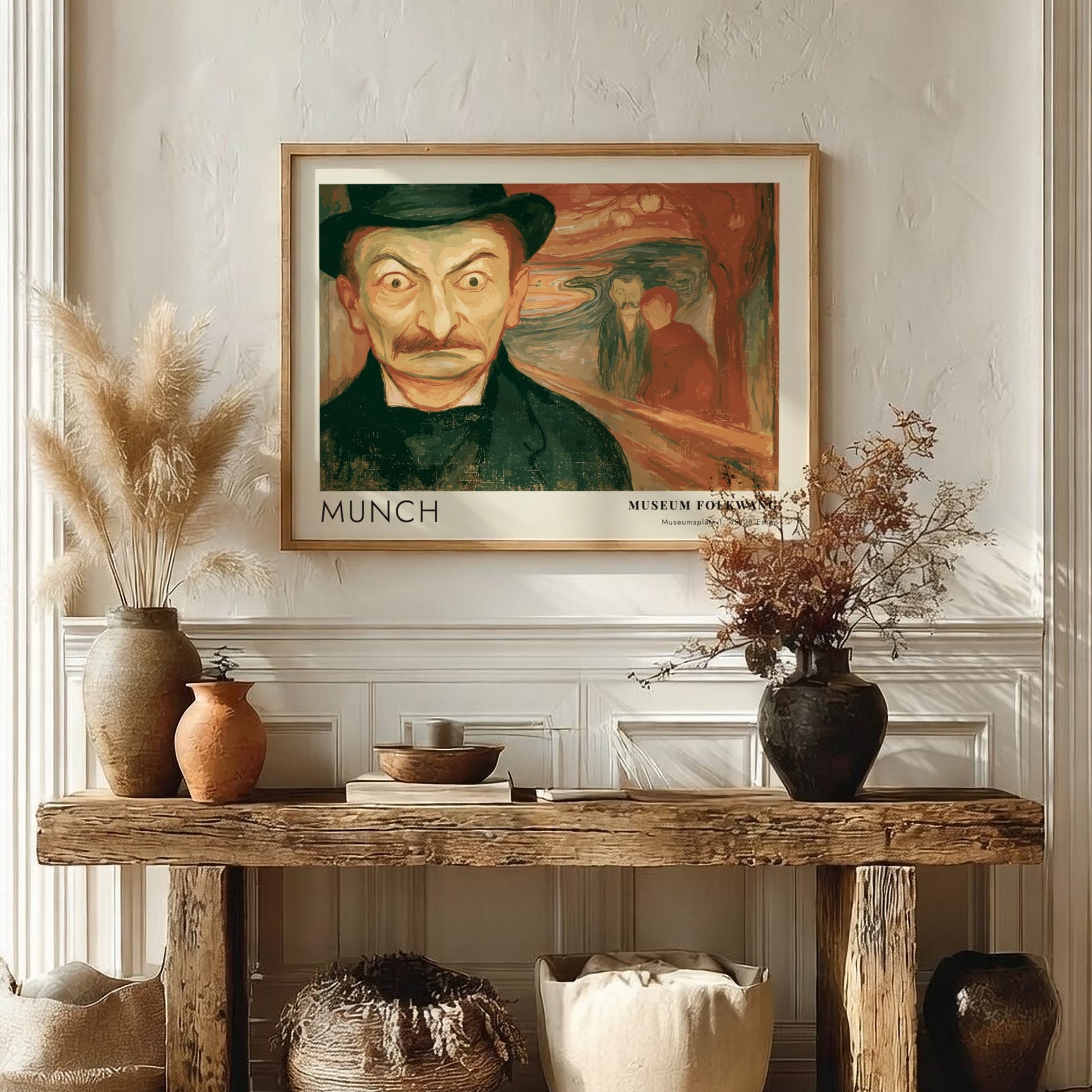 Exhibition poster featuring a wide-eyed man by Munch in a wooden frame display.
