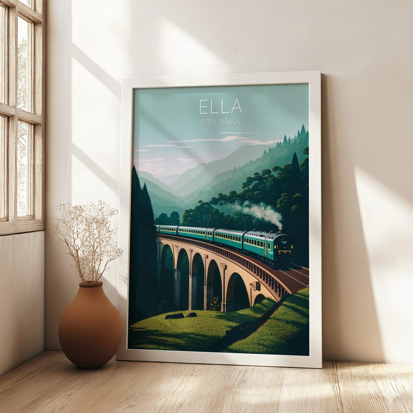 Framed artwork of a train on a bridge with 'Ella Sri Lanka' text, placed in a room with a vase and window.