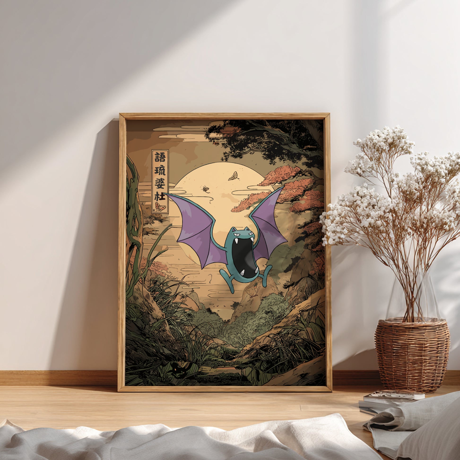 Framed artwork of Golbat Pokemon in a natural setting on a wall with a vase of dried flowers.