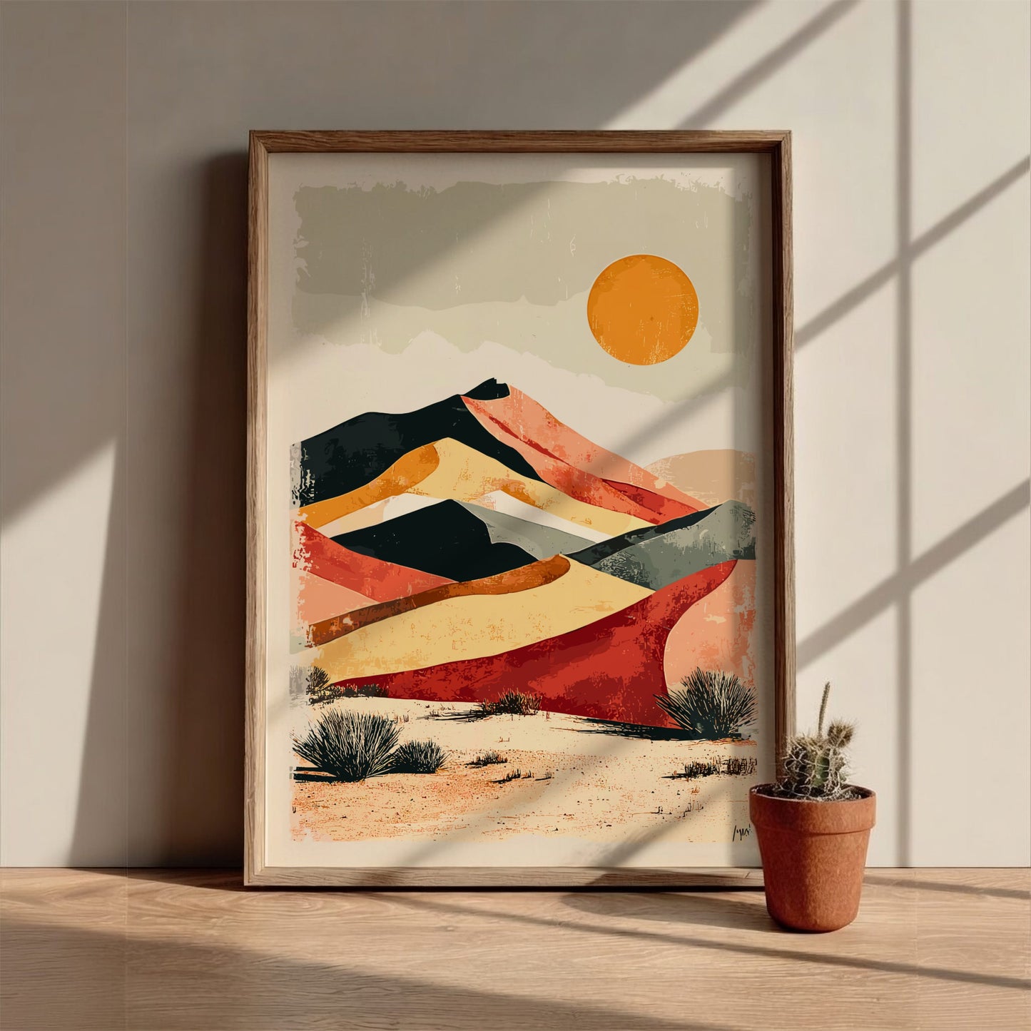 Framed abstract landscape art on a wall with a potted plant below.