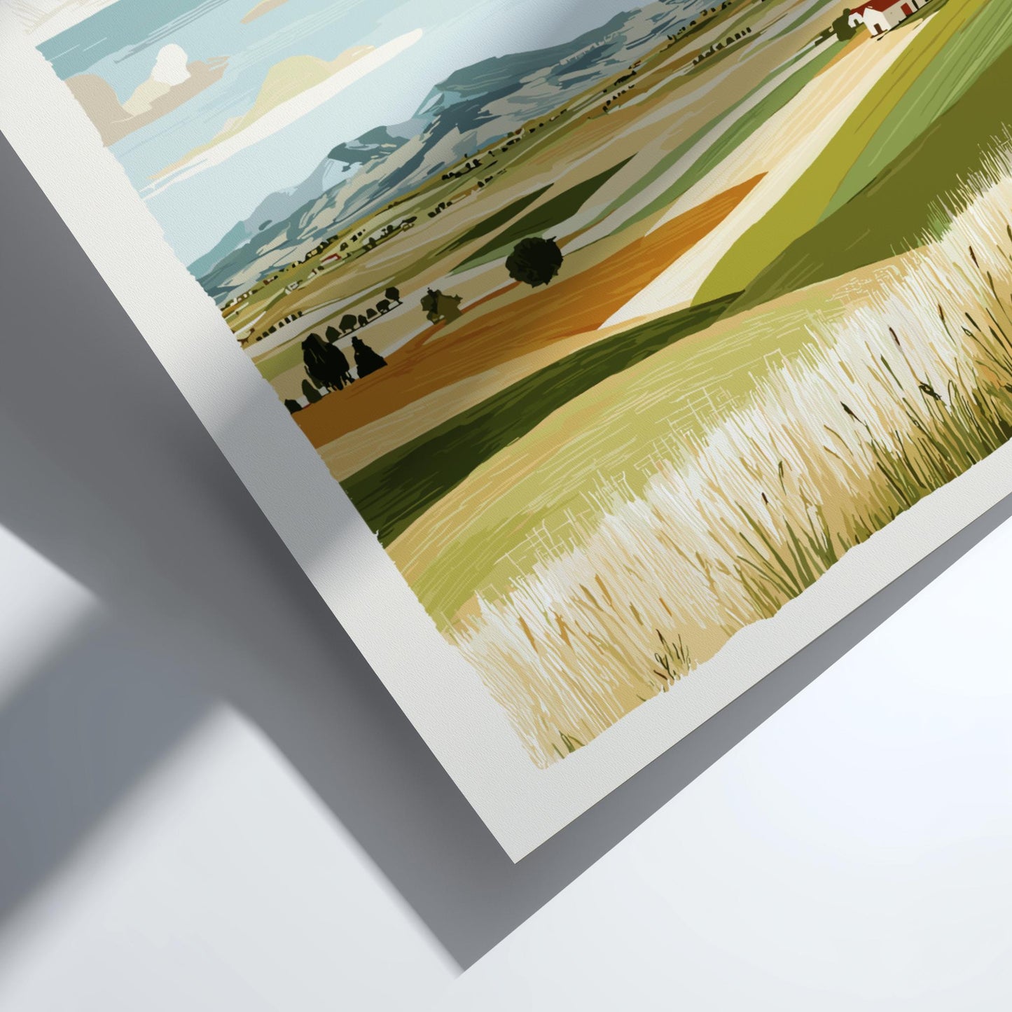 Framed artwork of a landscape with fields and trees on a white surface