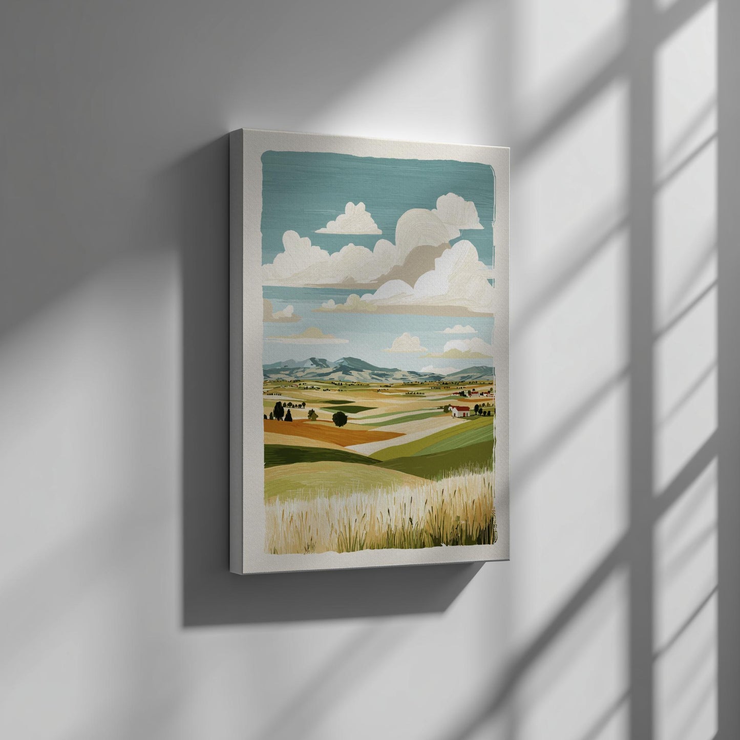 Canvas artwork of a landscape with fields and clouds on a wall.