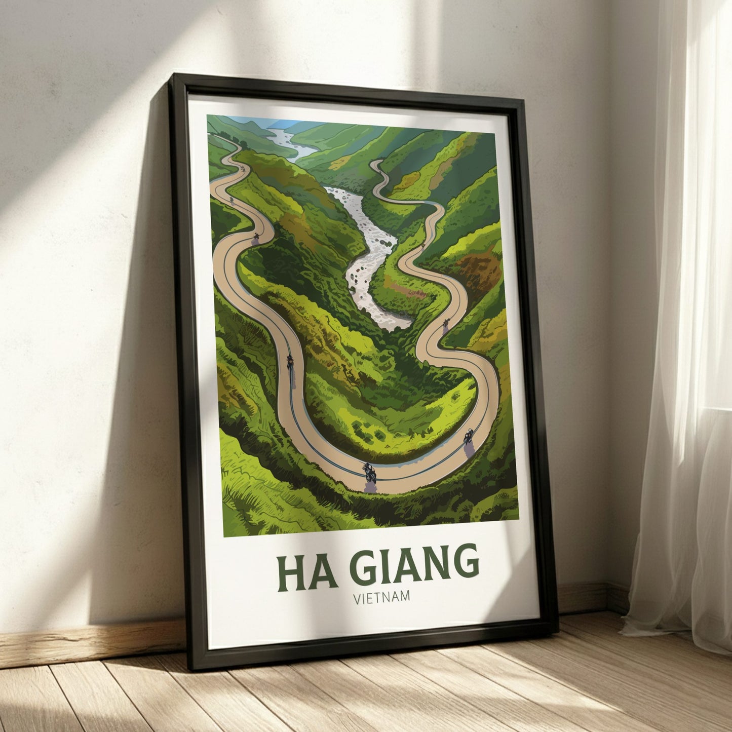 Framed poster of a winding road in Ha Giang, Vietnam on a wall.