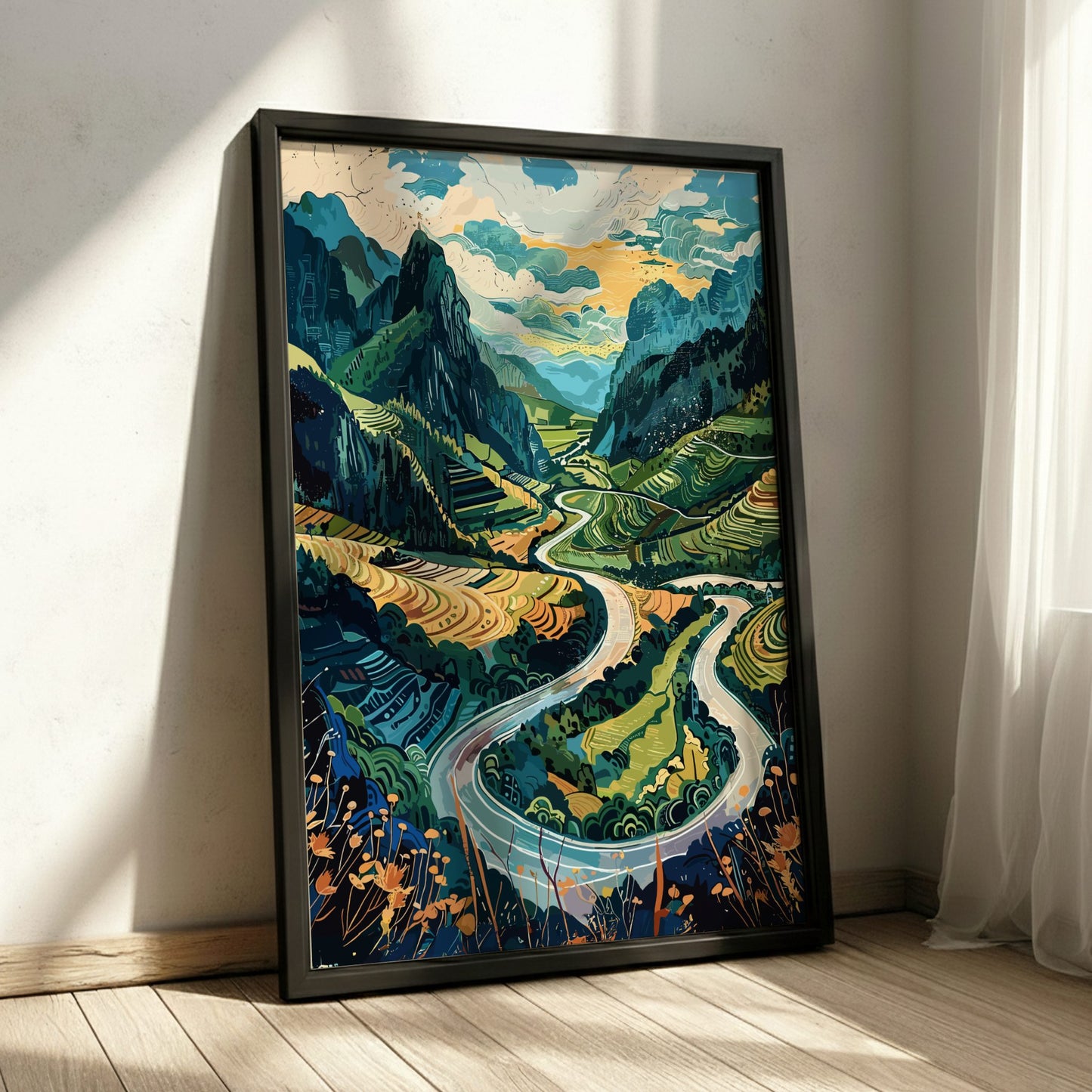 Framed artwork of a mountain landscape with a winding road on a wall.