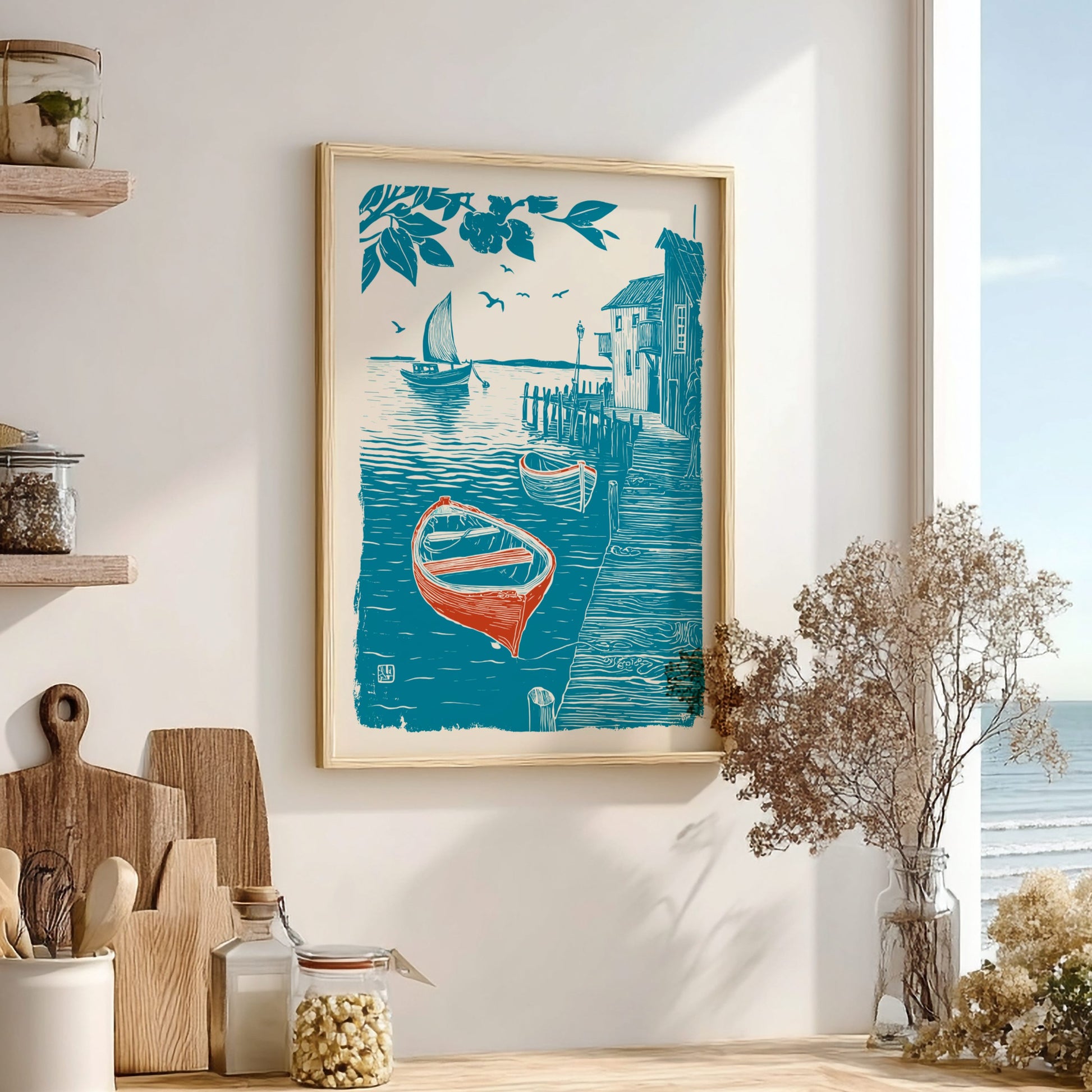 Framed artwork of a coastal scene with boats and houses on a wall in a room with wooden shelves and decor.