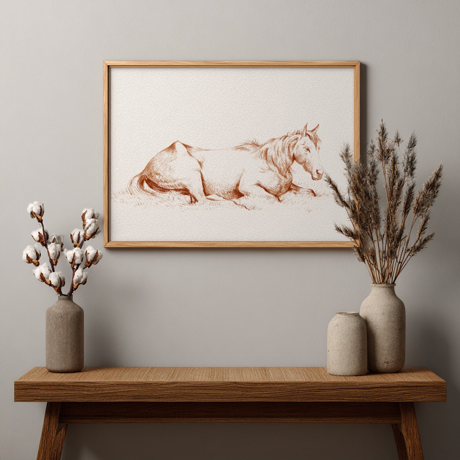 Vintage drawing of a horse lying in grass, rendered in brown ink, framed in wood.