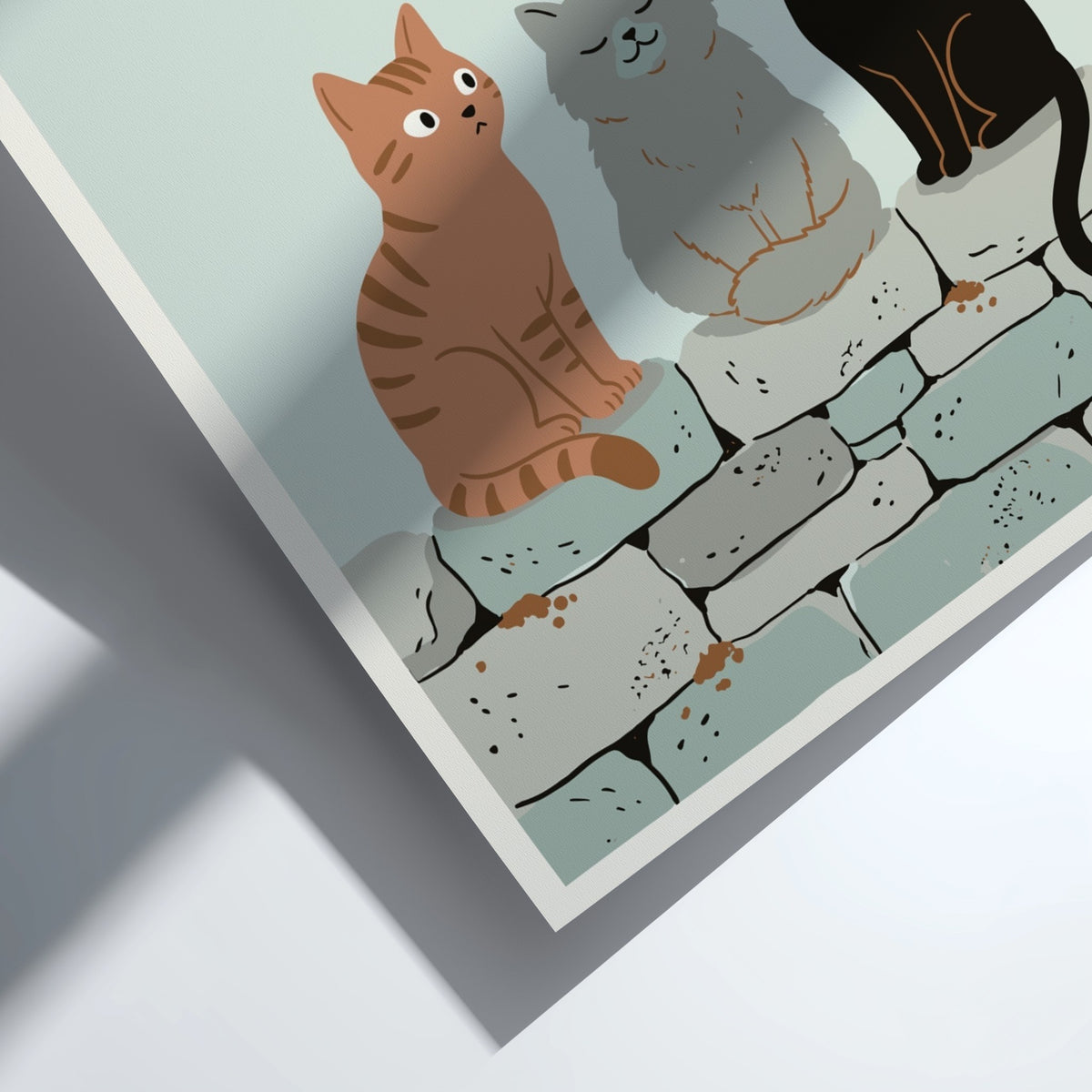 Poster featuring three cats in ginger, grey, and black sitting on a stone wall.