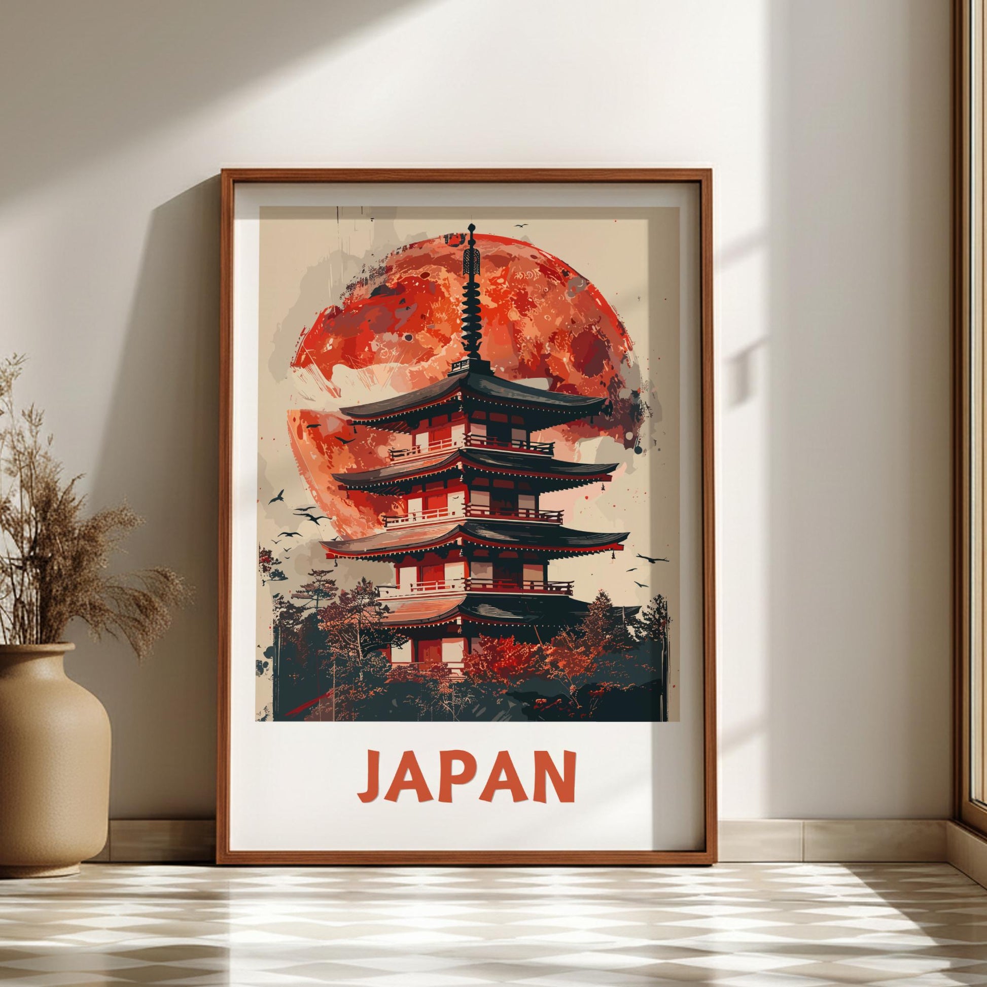 Framed artwork of a Japanese temple with a red moon in a room with a vase and plant.