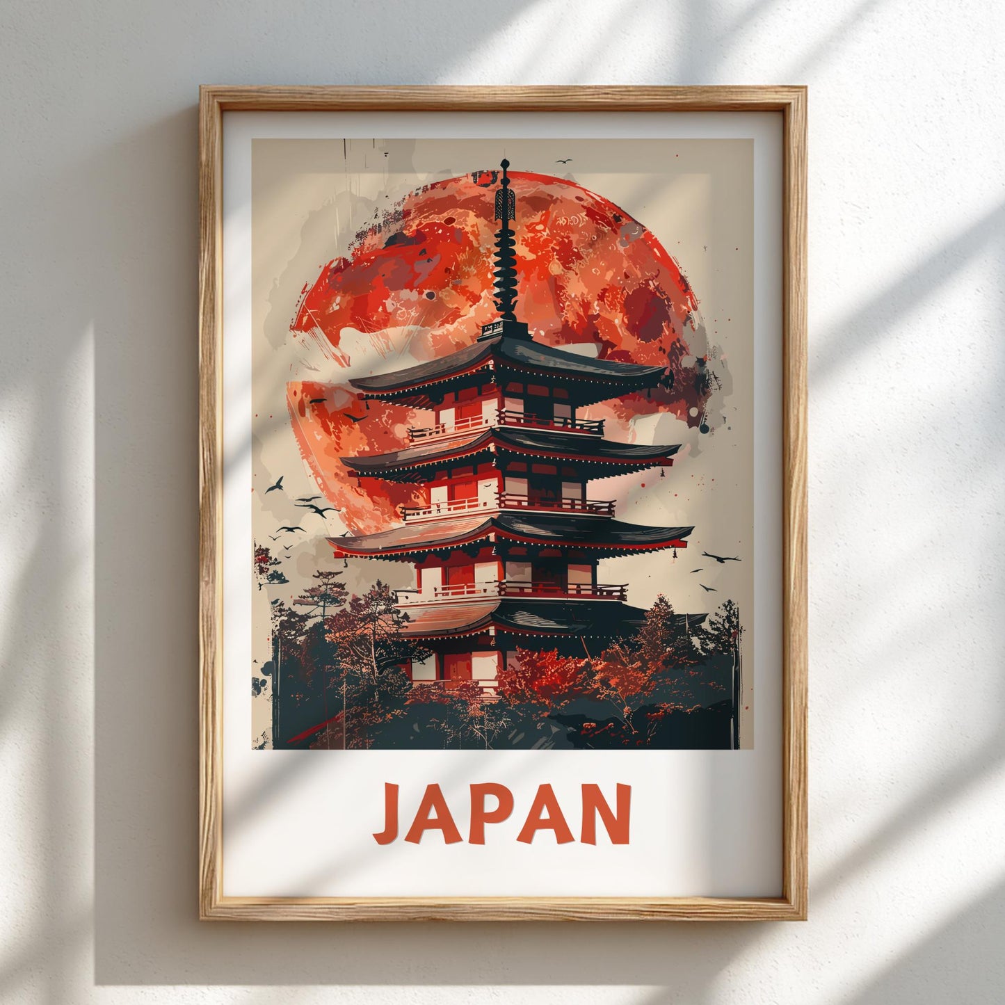 Framed artwork of a Japanese temple with a red moon on a white wall.