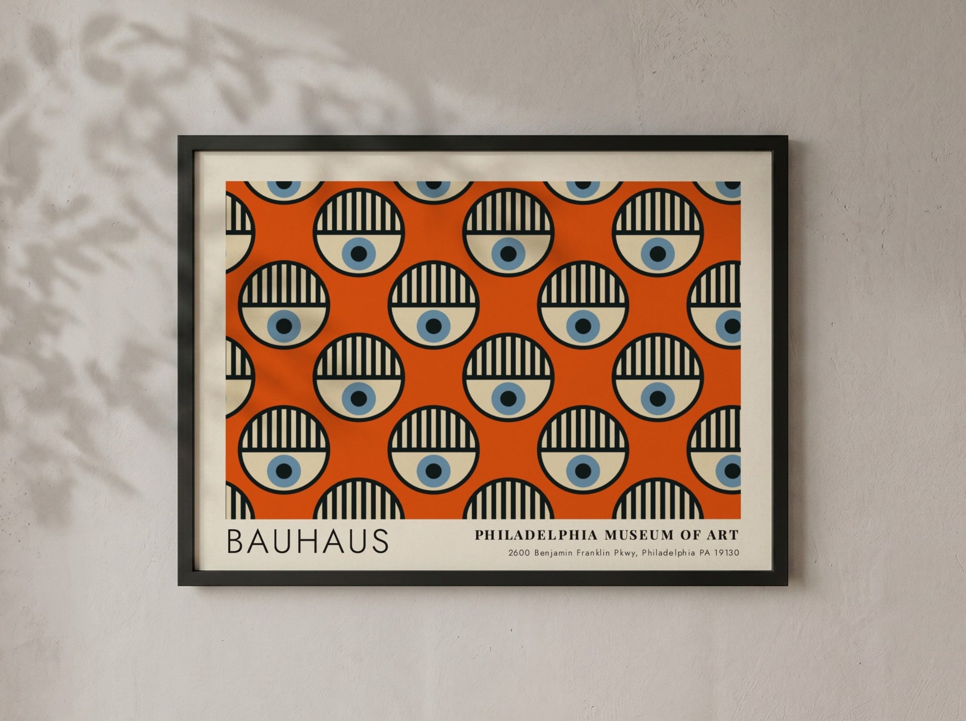 Bauhaus Philadelphia Museum of Art poster featuring repeating circular eye motifs on orange.