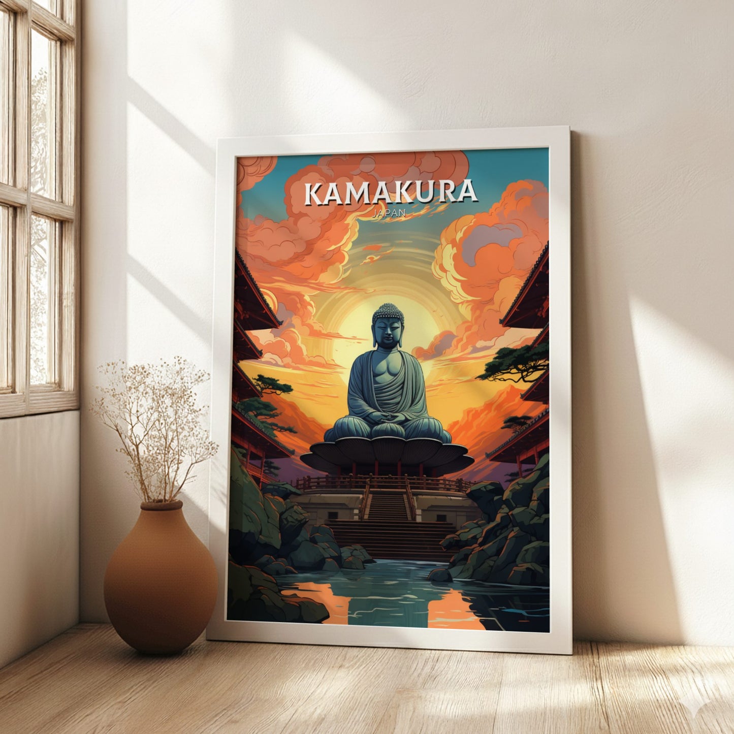 Framed poster of a Buddha statue with 'Kamakura' text in a room with a vase and plant.