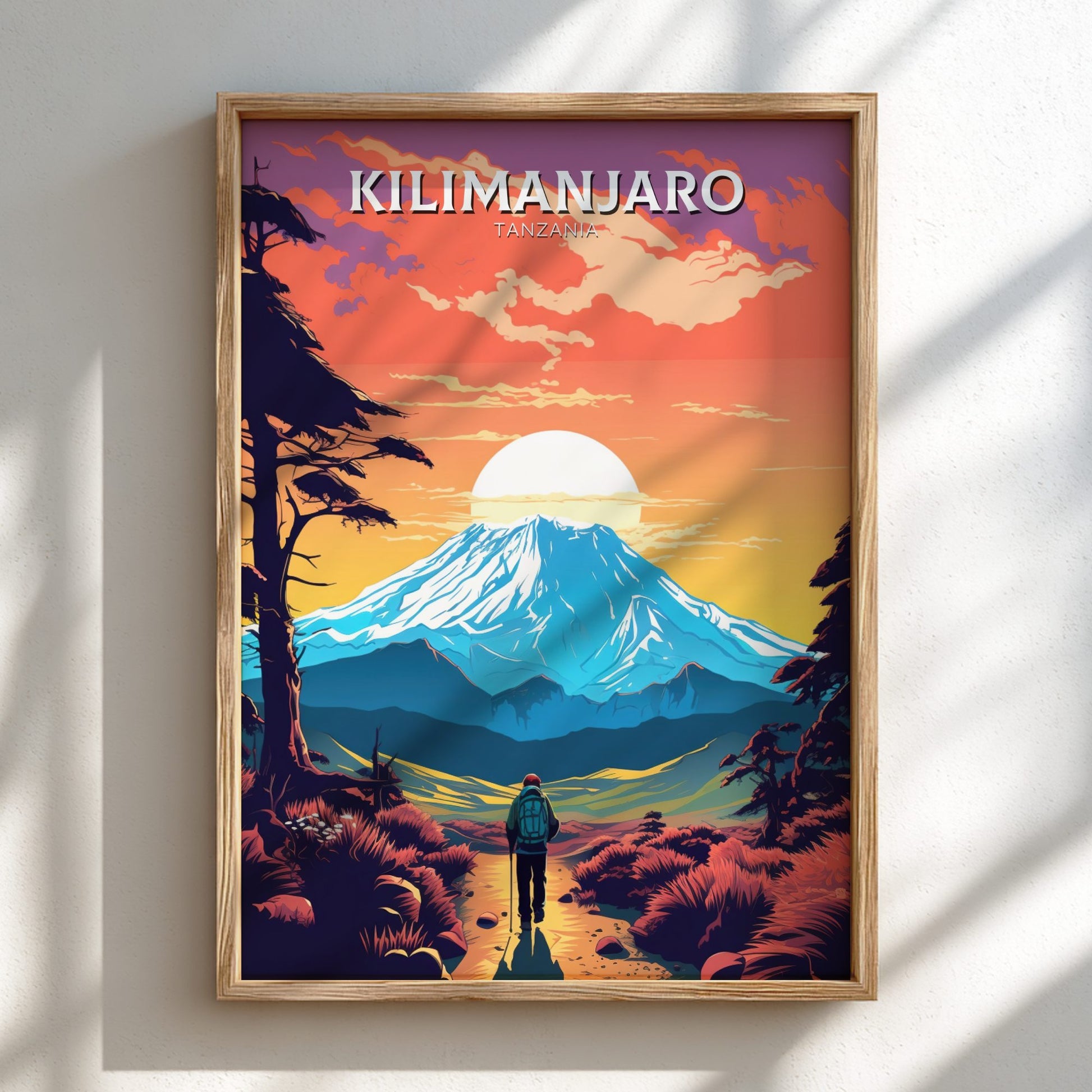 Framed artwork of a mountain landscape with 'Kilimanjaro' text on a white wall.