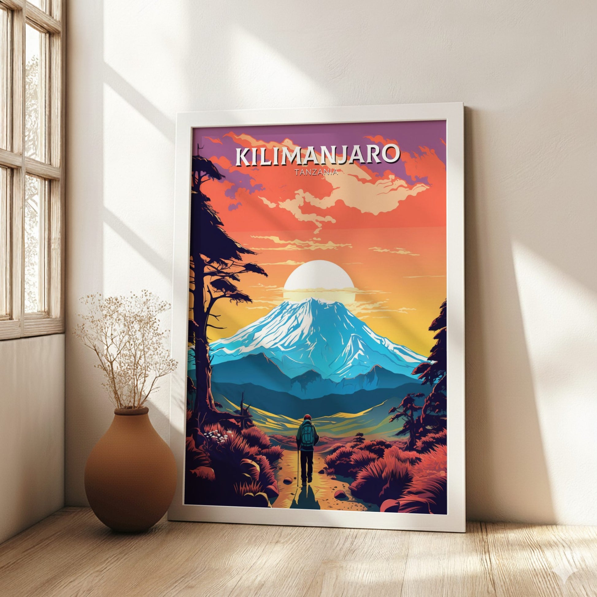 Framed poster of Mount Kilimanjaro with a colorful landscape in a room with a vase on the floor.