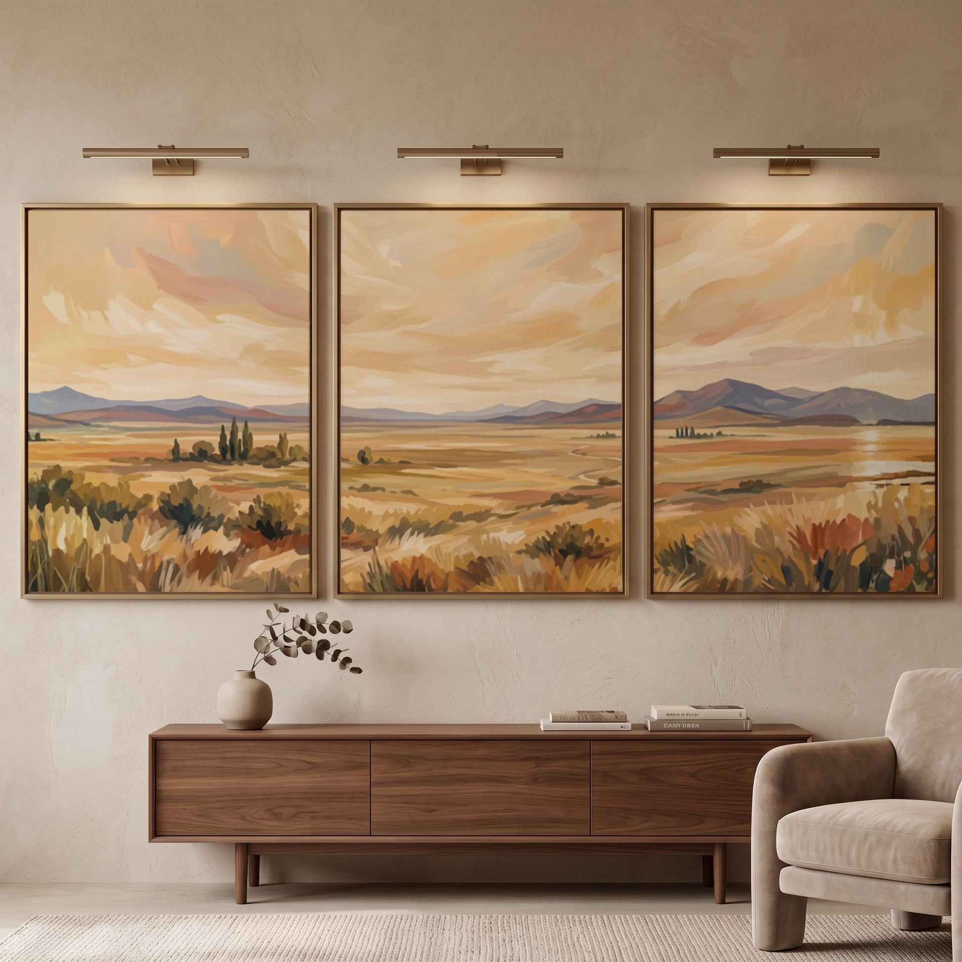 Three framed landscape prints showing golden prairies and distant mountains in a painterly style.