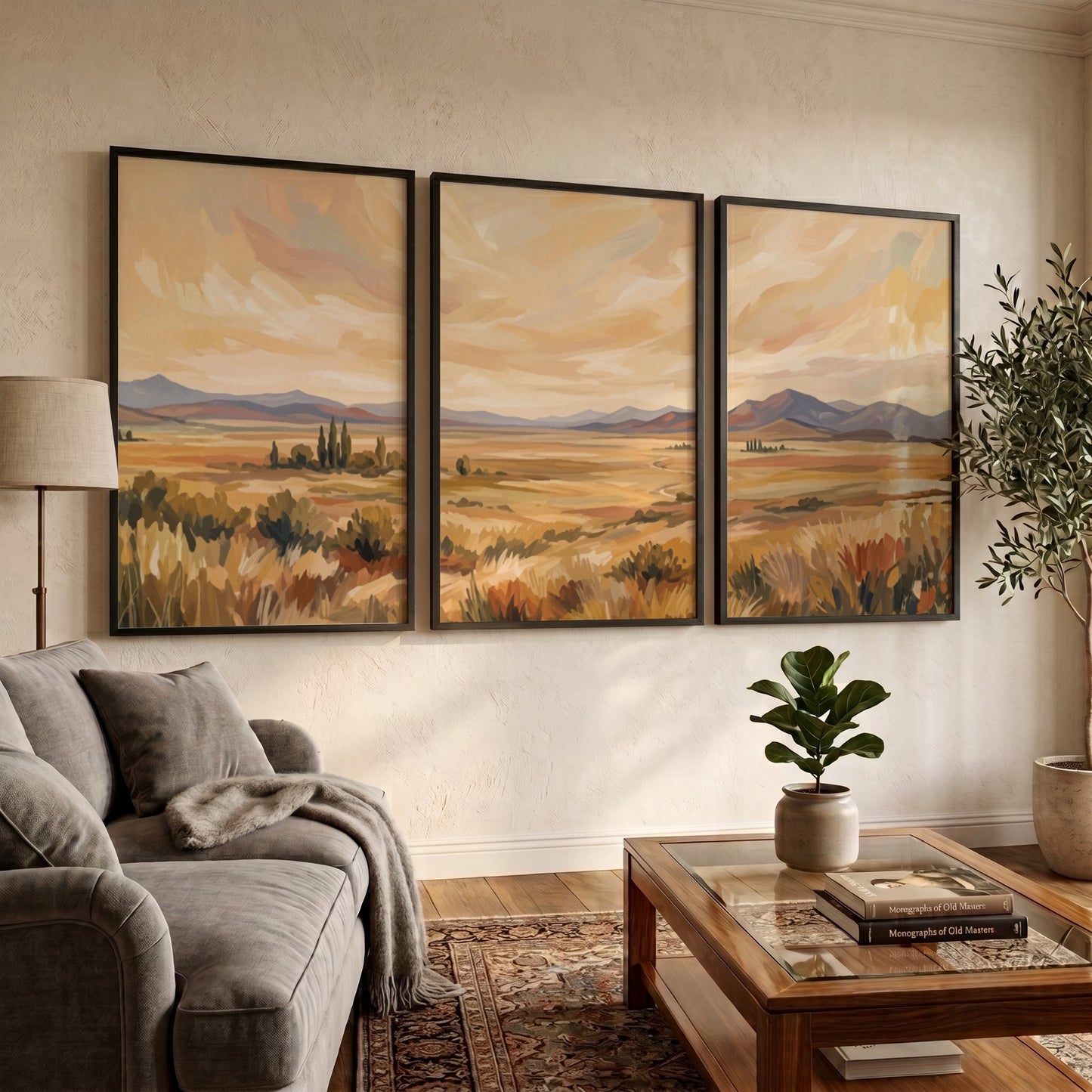 Three framed landscape prints showing golden prairies and distant mountains in a painterly style.