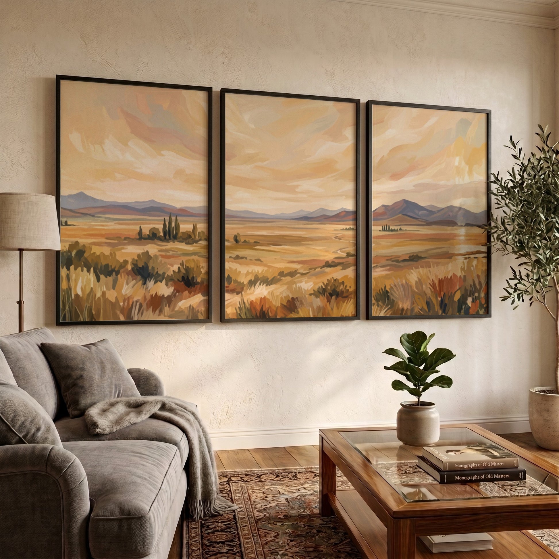 Three framed landscape prints showing golden prairies and distant mountains in a painterly style.