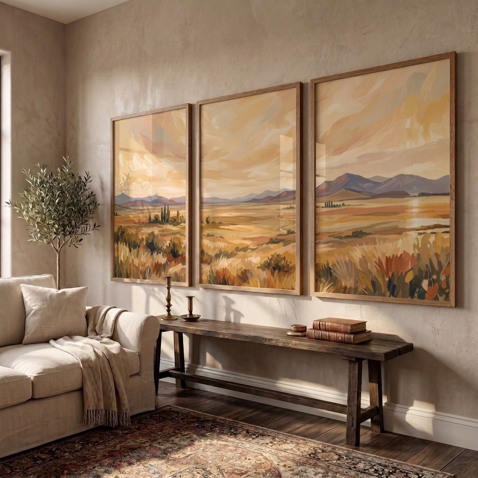 Three framed landscape prints showing golden prairies and distant mountains in a painterly style.