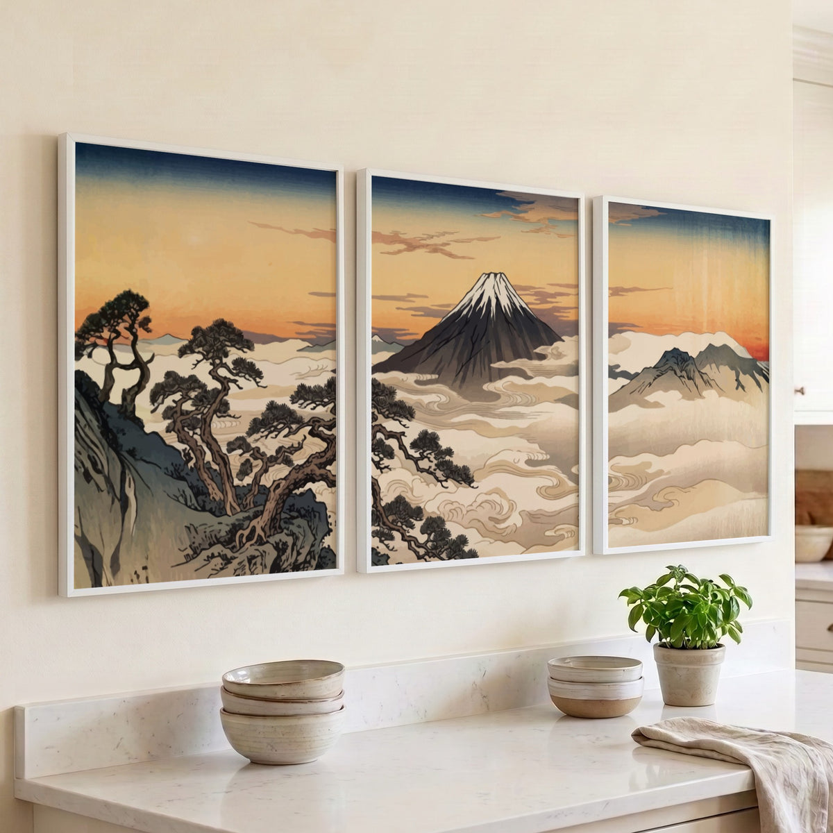 Three framed Japanese landscape prints featuring Mount Fuji rising above clouds at sunset
