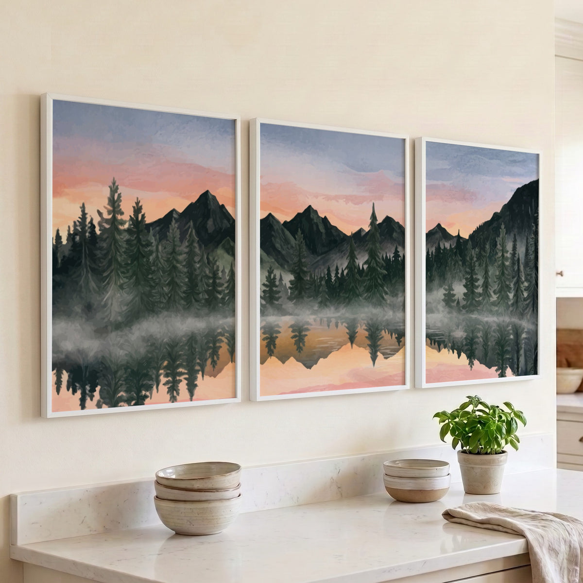 Three framed landscape prints showing misty mountains and pine trees reflected in water