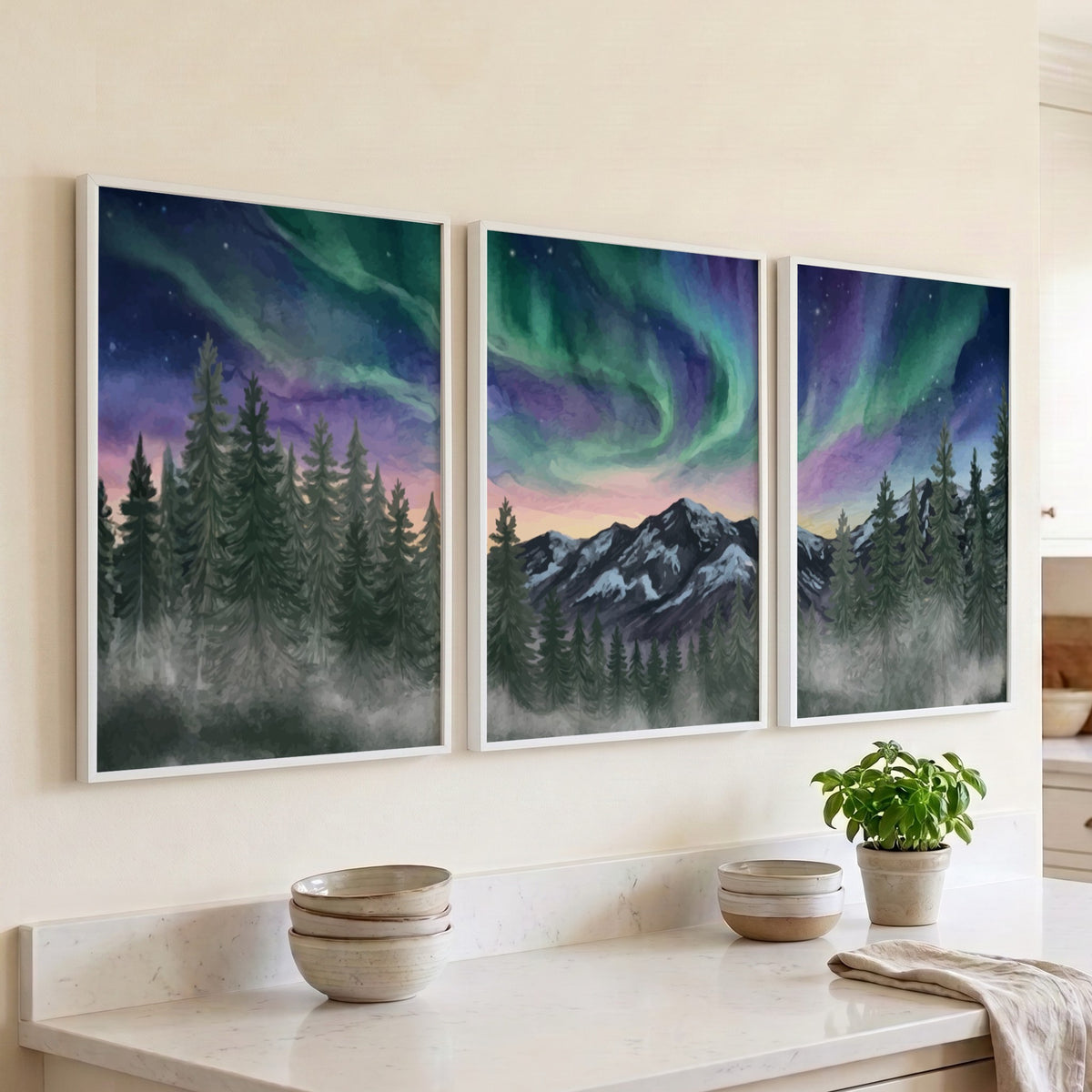 Three framed landscape prints showing green and purple aurora borealis over mountain forests