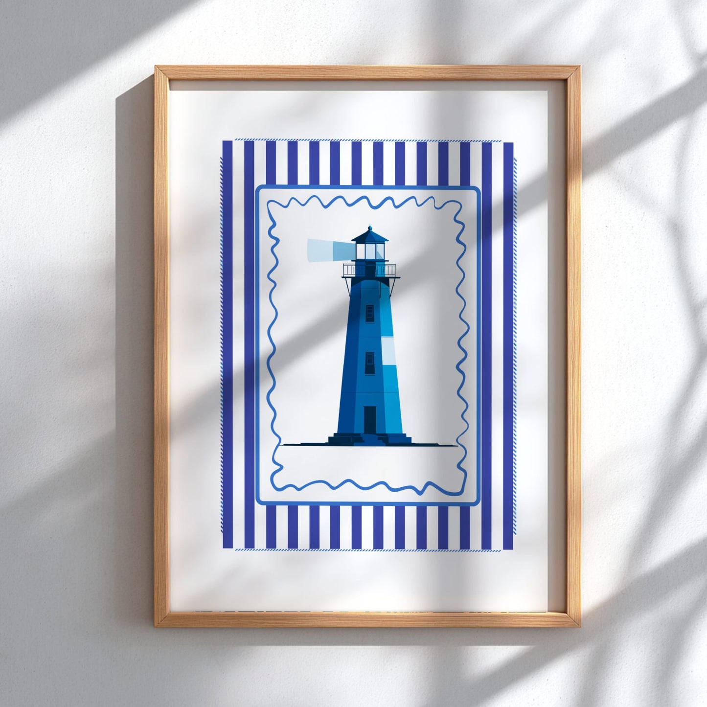 Framed artwork of a blue lighthouse with a striped border on a white wall.