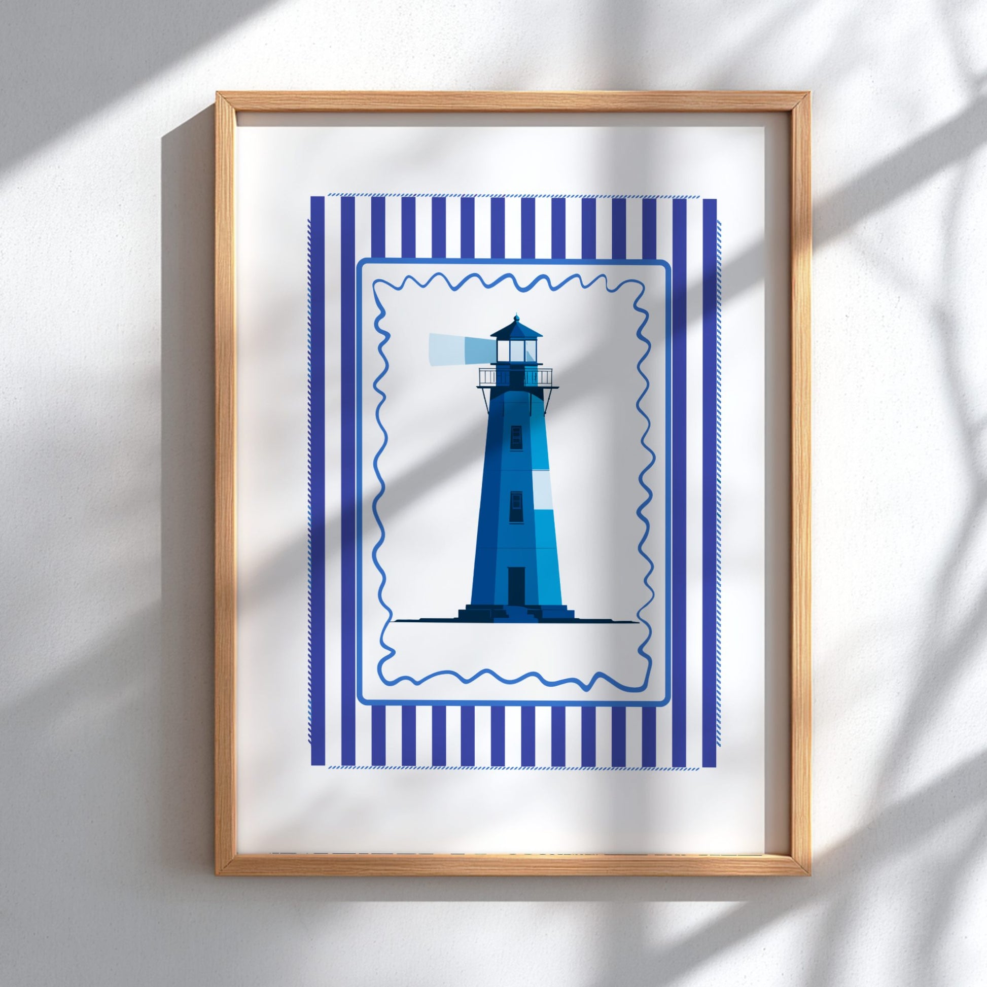 Framed artwork of a blue lighthouse with a striped border on a white wall.