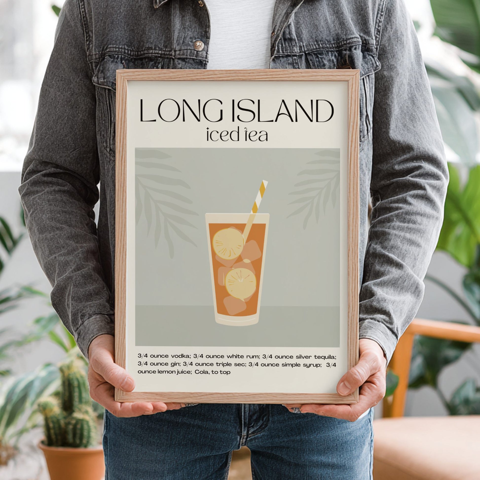 Person holding a framed poster of a Long Island iced tea recipe.